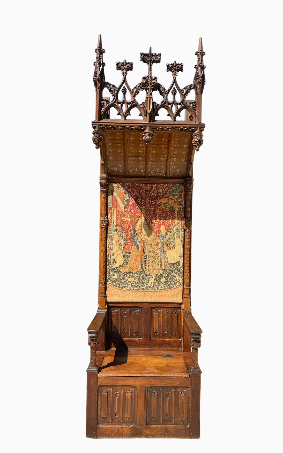 Eichenholzthron im gotischen Stil oder gotischer Schloss-Sessel. Prächtiger und monumentaler Thron aus massiver Eiche im Stil der gotischen Burg. Französisches Werk aus dem 19. Jahrhundert mit einem Wandteppich auf der Rückseite, der das 