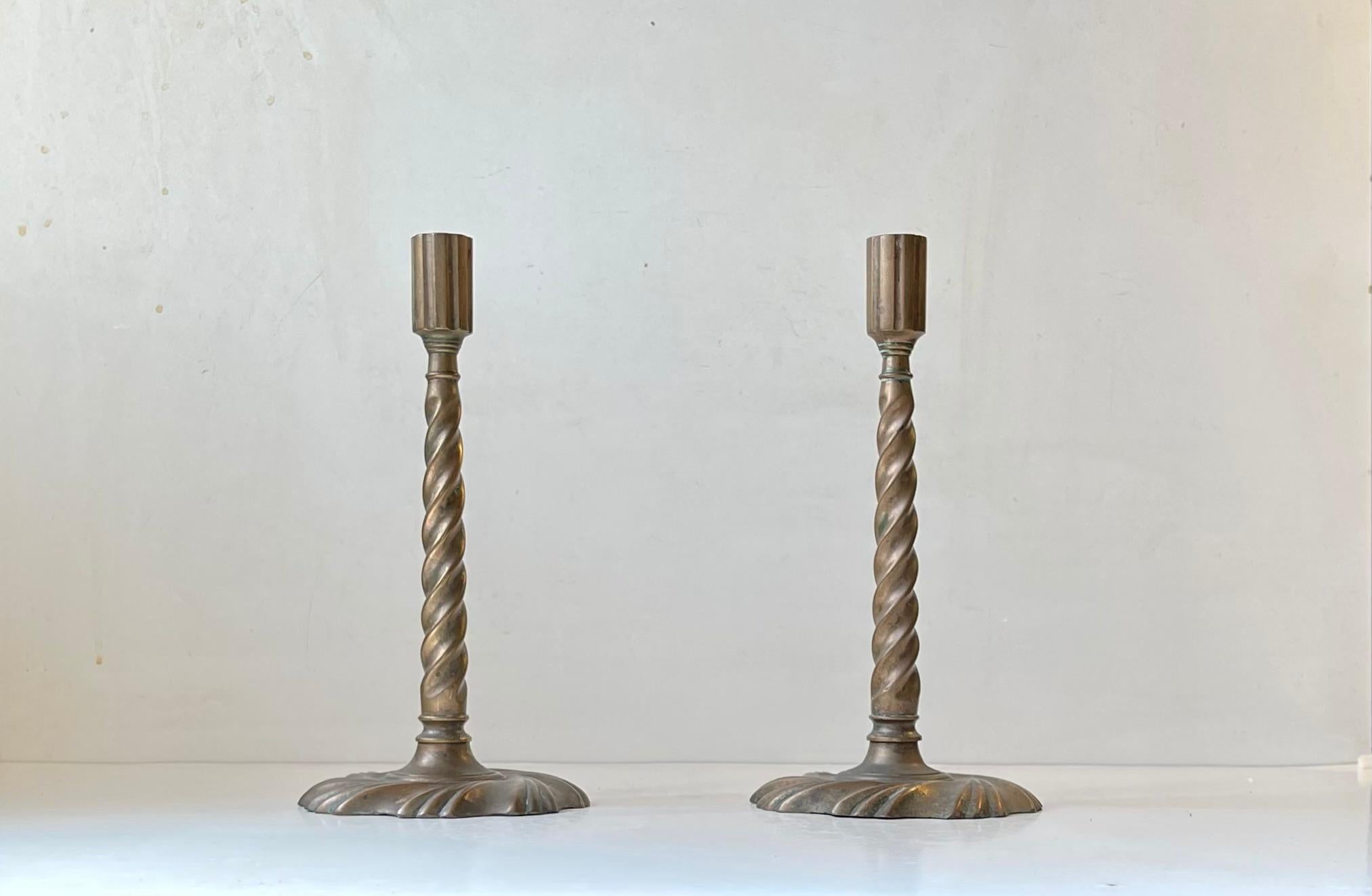 A pair of Barley twisted candlesticks in patinated bronze. Made in Scandinavia or England circa 1850-1880. Great authentic Gothic/Gothic revival look due to the excessive patina and stylized beautifully cast details. They are to be installed with