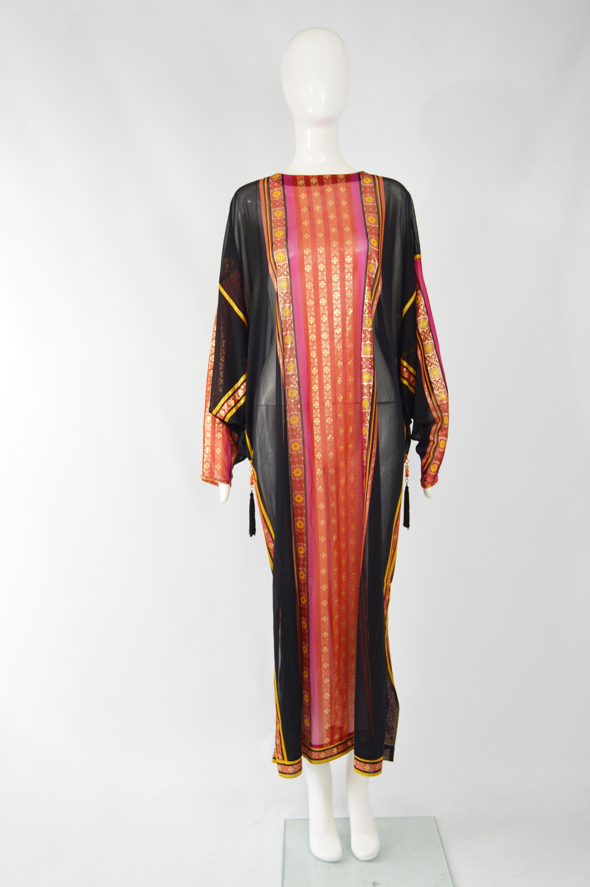 An amazing vintage kaftan dress from the 70s by rare and luxury Israeli label, Gottex. In a sheer black jersey with opulent pink, red and gold brocade details and a loose, batwing design. 

Size: Marked L 
Bust - Free
Waist - Free
Hips - Free
Length