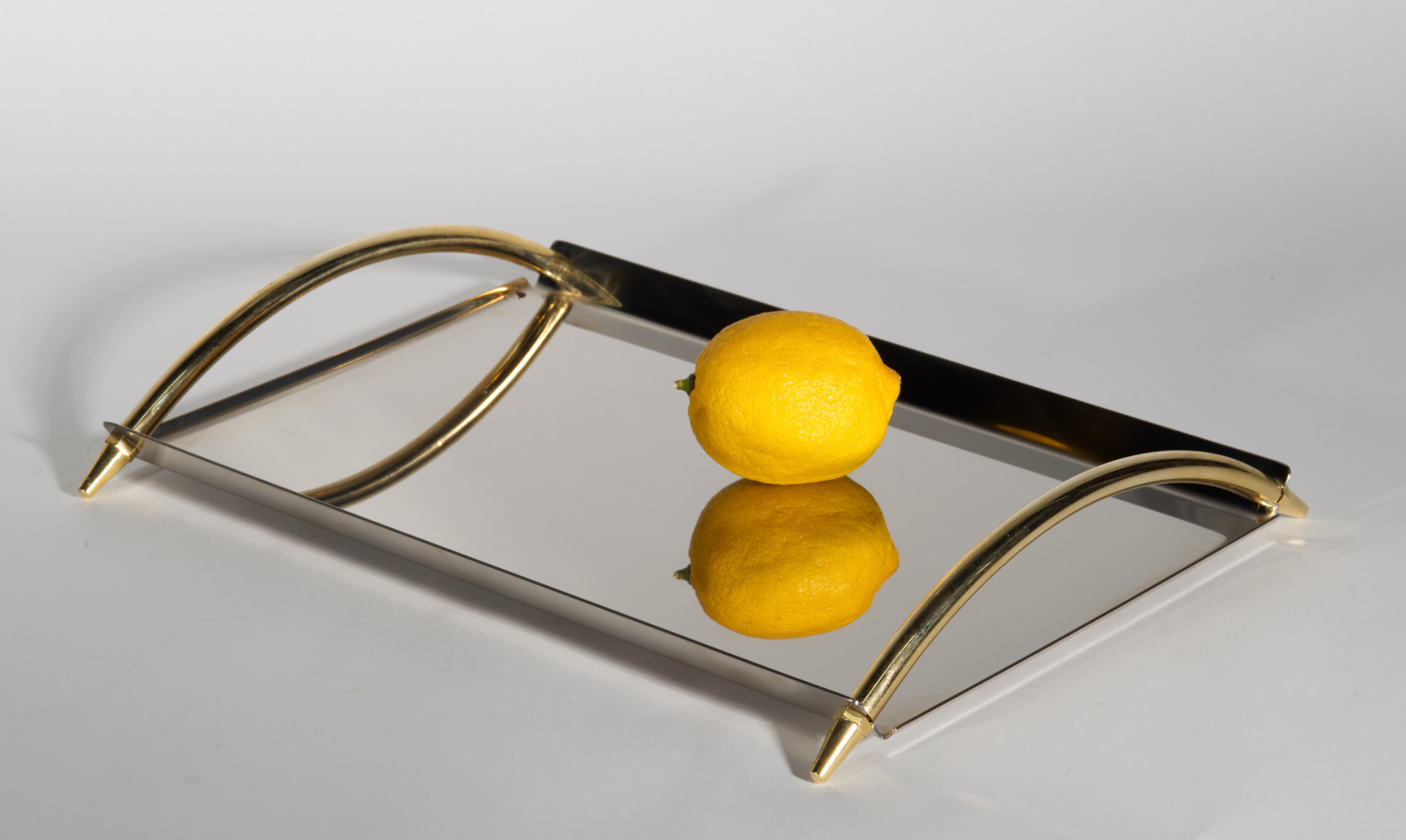 Elegantes Serviertablett im Vintage-Stil mit rechteckigem Korpus aus Edelstahl und abgerundeten Griffen aus Bronze. Die minimale, skulpturale Präsentation des Tabletts ist stark vom Art Deco und dem Mid-Century Modern beeinflusst. Hochreflektierende