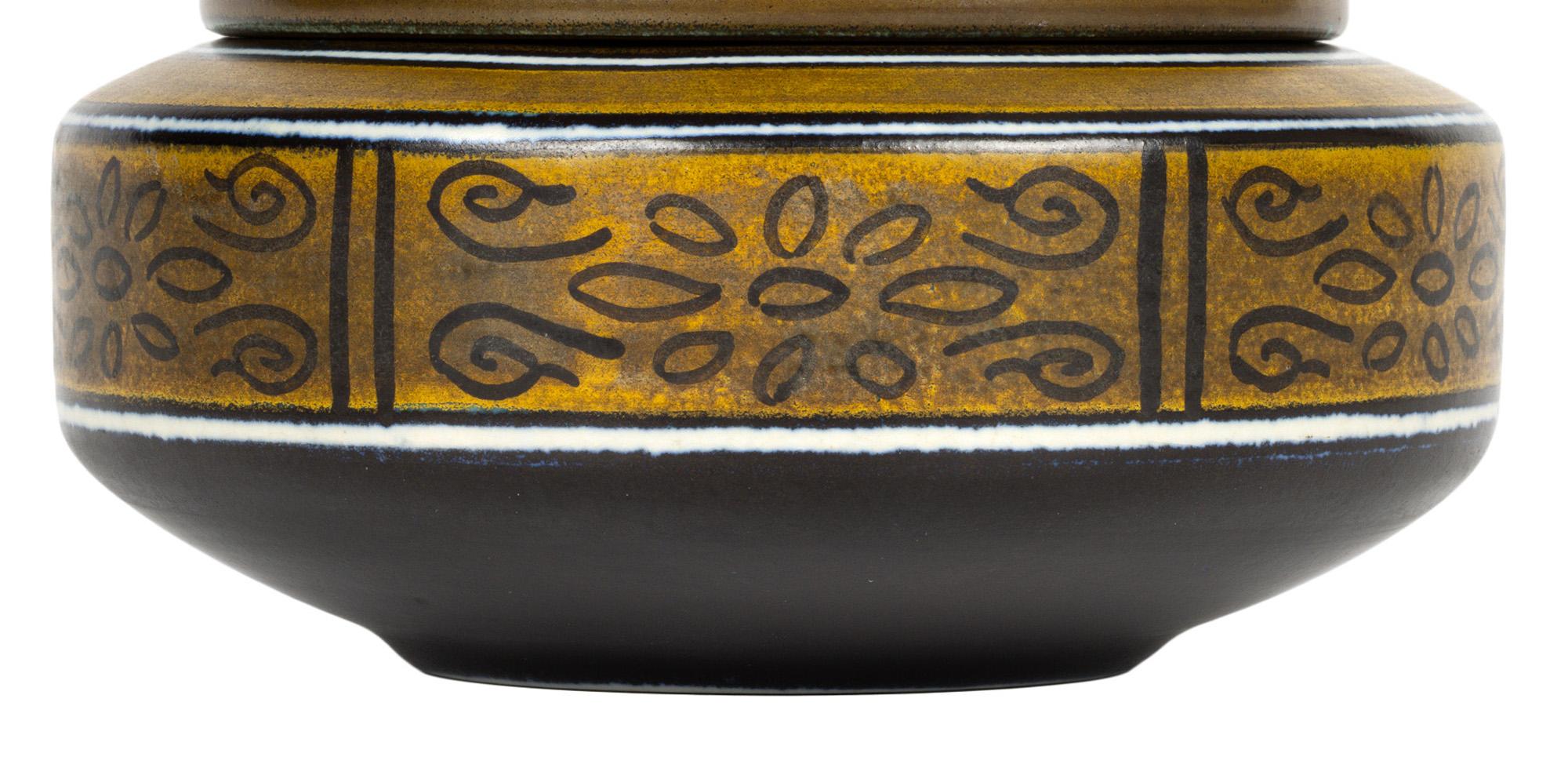A stylish Dutch Gouda art deco pottery lidded pot decorated in the Sydney pattern made at Plateelbakkerij Zuid-Holland (Plazuid) and dating from the 1920’s. The attractive and unusual shaped pot of is of elegant squat wide rounded form raised on a