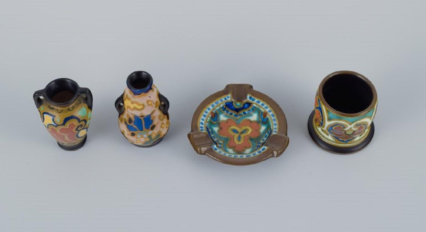Gouda, Holland. Art Nouveau hand-decorated ceramics.
Four miniature vases and a bowl.
Approx. 1920s.
In perfect condition.
Signed.
Largest vase: H 6.5 x D 4.5 cm.
Bowl: D 8.0 x H 2.0 cm.