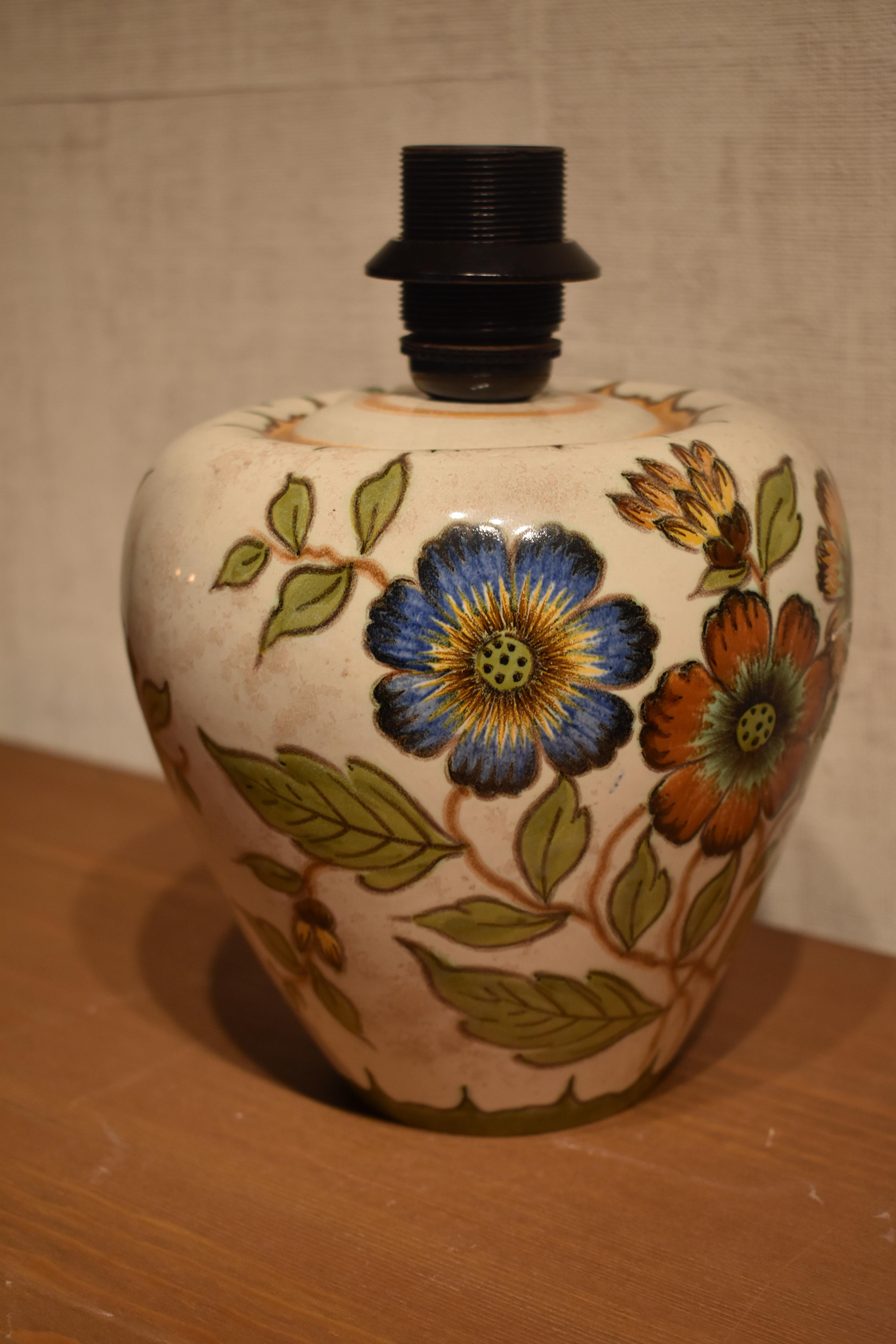 This lovely ceramic table lamp is created by Gouda Holland in a typical Dutch style. It features a beautiful decor of flowers, which are somewhat reminiscent to Van Gogh's flower paintings.