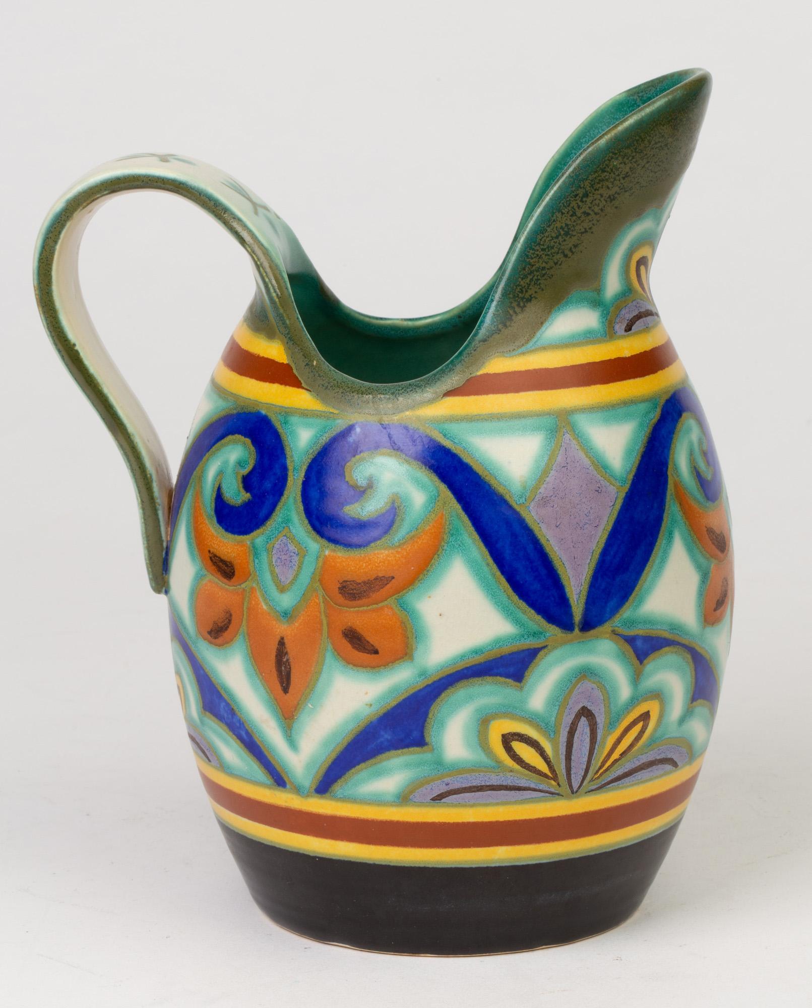 A stunning Dutch Gouda, Plateelbakkerij Zuid-Holland Art Deco pottery jug hand painted in the Neloca design and dating between 1920 and 1929. The rounded bulbous shaped jug has a large raised lip shaped pouring spout and a looped strap handle and is