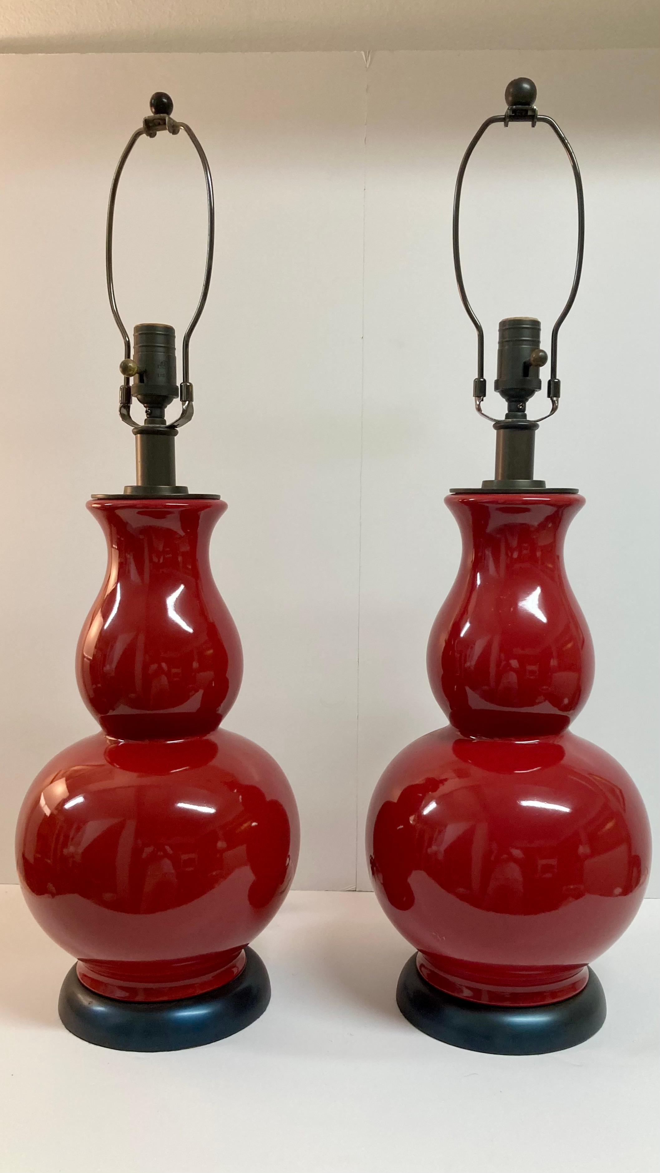 Pair of gourd shaped apple red glazed ceramic table lamps. Beautiful detail work and hardware. Just add your favorite shade style.