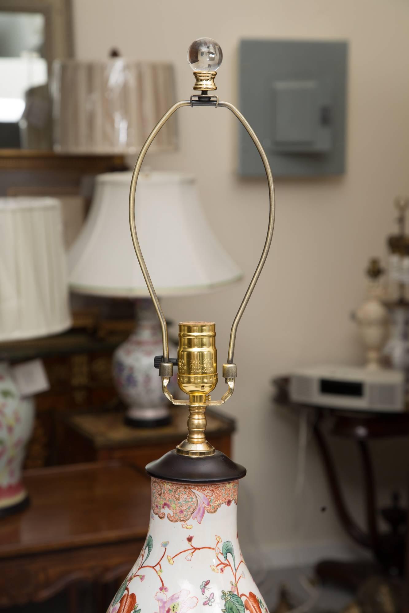 This pair of gourd shaped table lamps has a white background hand-painted with a floral design in the French manner.