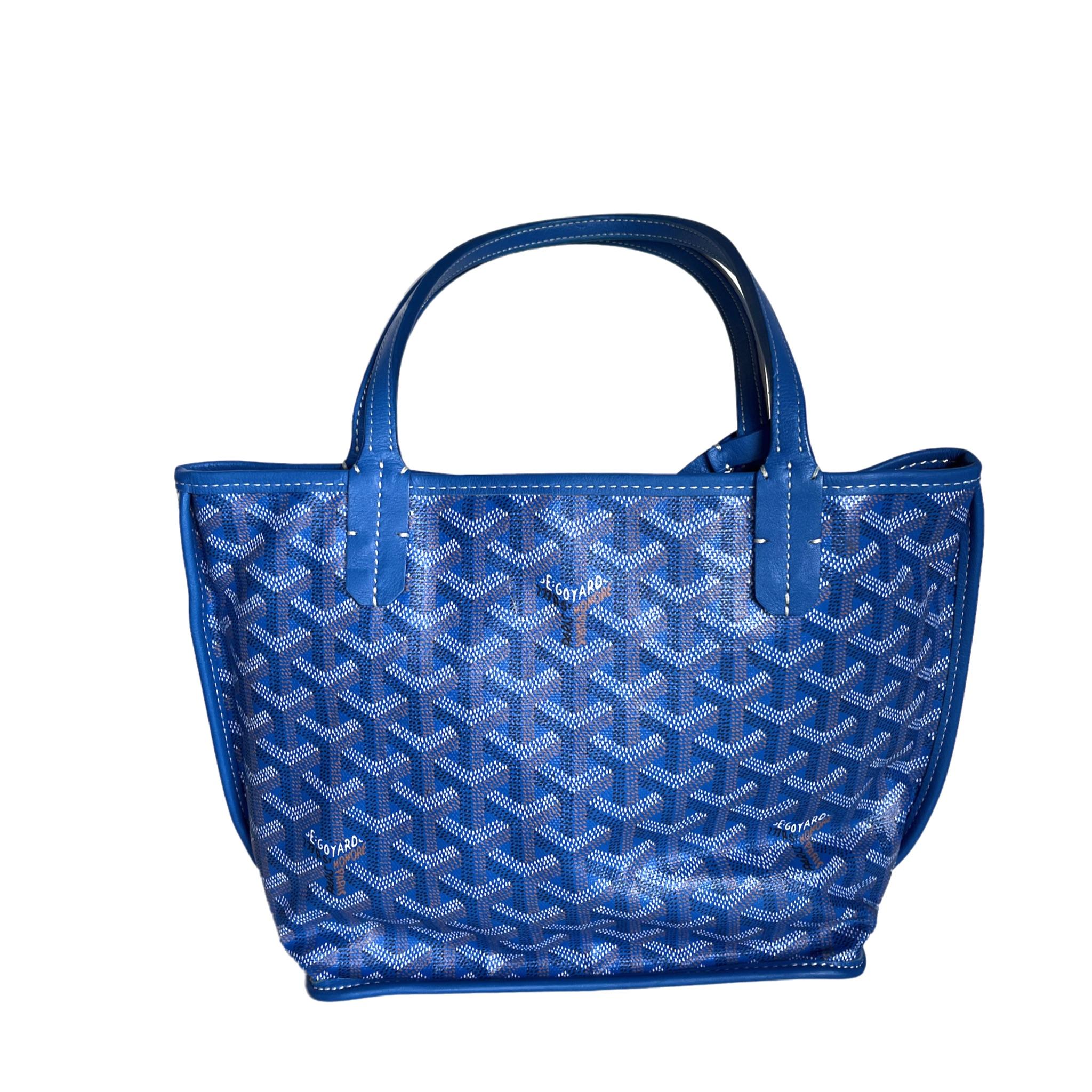 Ce mini fourre-tout Goyard Anjou est une pièce emblématique de l'artisanat français, confectionnée avec expertise dans un cuir bleu très convoité. Le fourre-tout est réversible et doublé de cuir d'agneau luxueusement doux. Cet accessoire intemporel