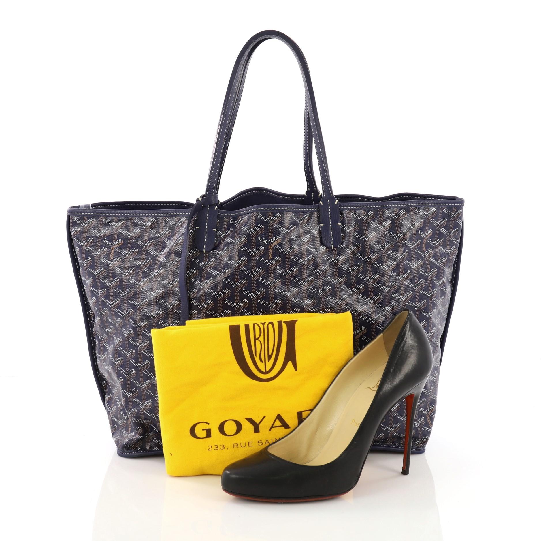 This Goyard Anjou Reversible Tote Coated Canvas PM, crafted in blue coated canvas, features dual-flat leather handles, black leather trim, and silver-tone hardware. It opens wide to a blue leather interior. **Note: Shoe photographed is used as a