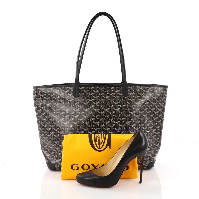 This Goyard Artois Tote Coated Canvas MM, crafted in black and brown coated canvas, features dual slim leather handles, leather trim, protective corner patches, and silver-tone hardware. Its zip closure opens to a beige canvas interior with a
