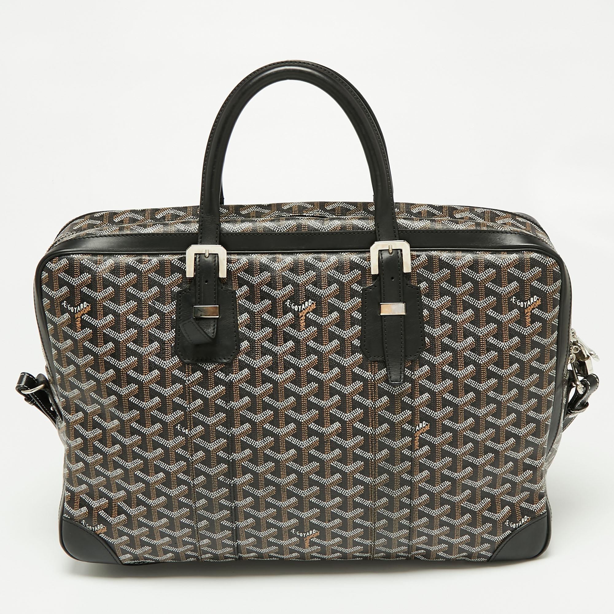 From the House of Goyard comes this Ambassade briefcase that will prove to be highly functional and useful to you. It is made from black Goyardine canvas and leather and comes with two top handles. It showcases silver-tone hardware and a