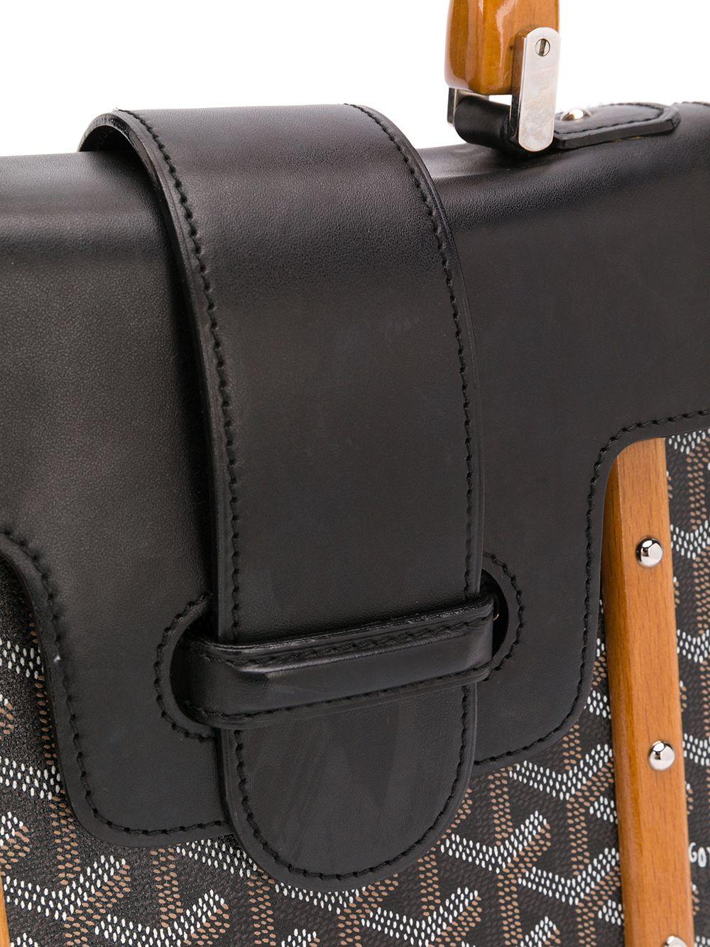 Fabriqué en France à partir de toile enduite de Goyardine, ce sac d'occasion Saigon de Goyard présente un corps structuré noir classique, l'imprimé géométrique emblématique ornant ses côtés et un rabat avant, fini en cuir de veau noir lisse assorti.