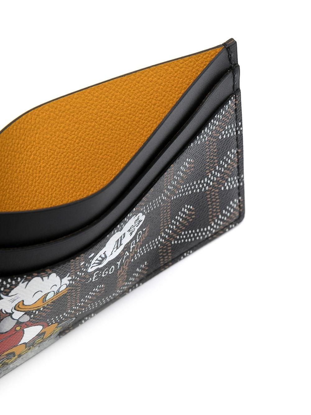 Crafted from Goyardine Canvas, a coloured textile made from cotton, linen and hemp, this black monogram Slot card Wallet from Goyard is adorned with an all-over cartoon print, especially hand-painted as a part of Rewind Vintage's Emotional Baggage