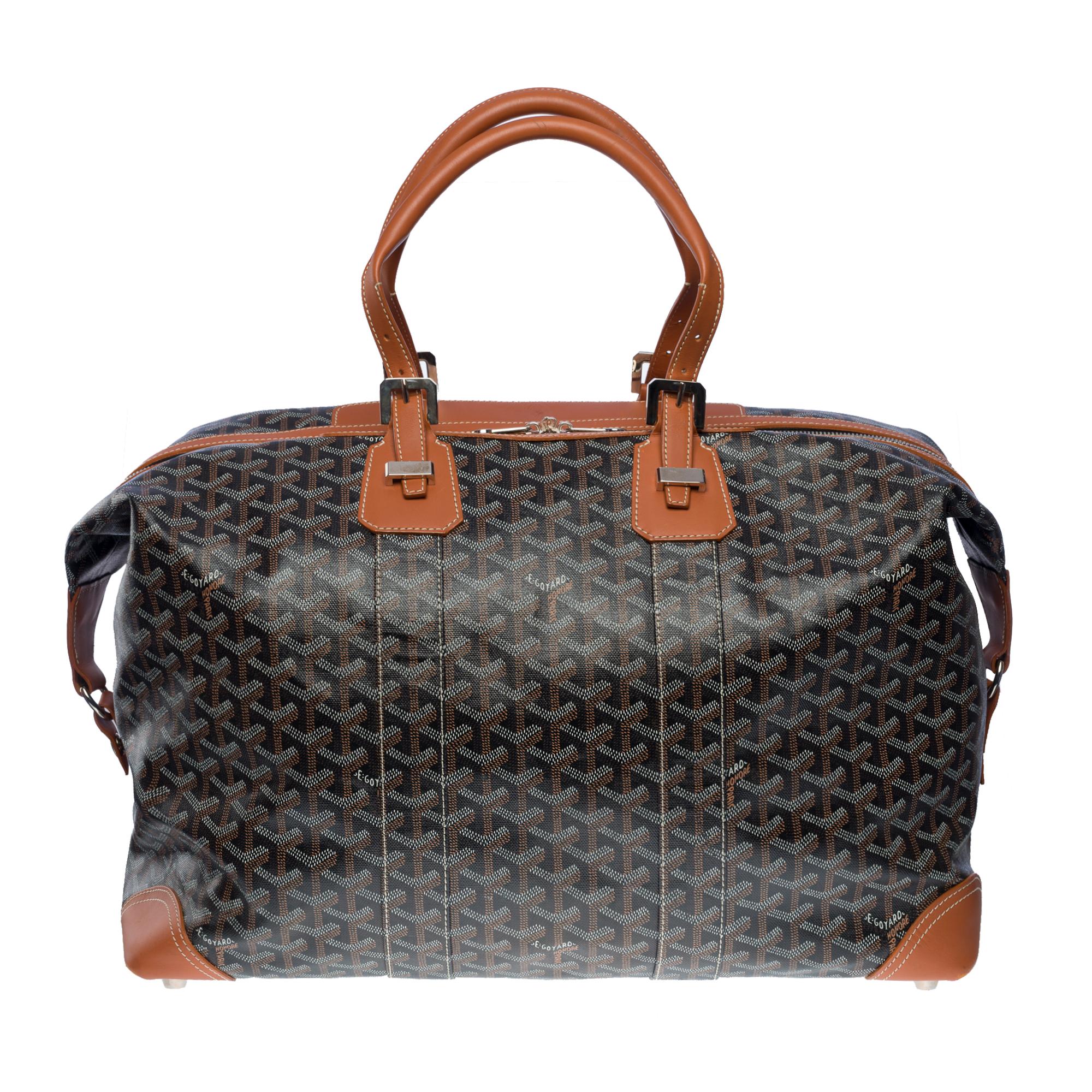 Elegant sac de voyage Goyard Boeing 45 en toile Goyardine noire et marron et cuir beige, quincaillerie en métal argenté, double poignée en cuir beige permettant un portage à la main.

Fermeture à glissière
Une poche frontale plaquée
Doublure en