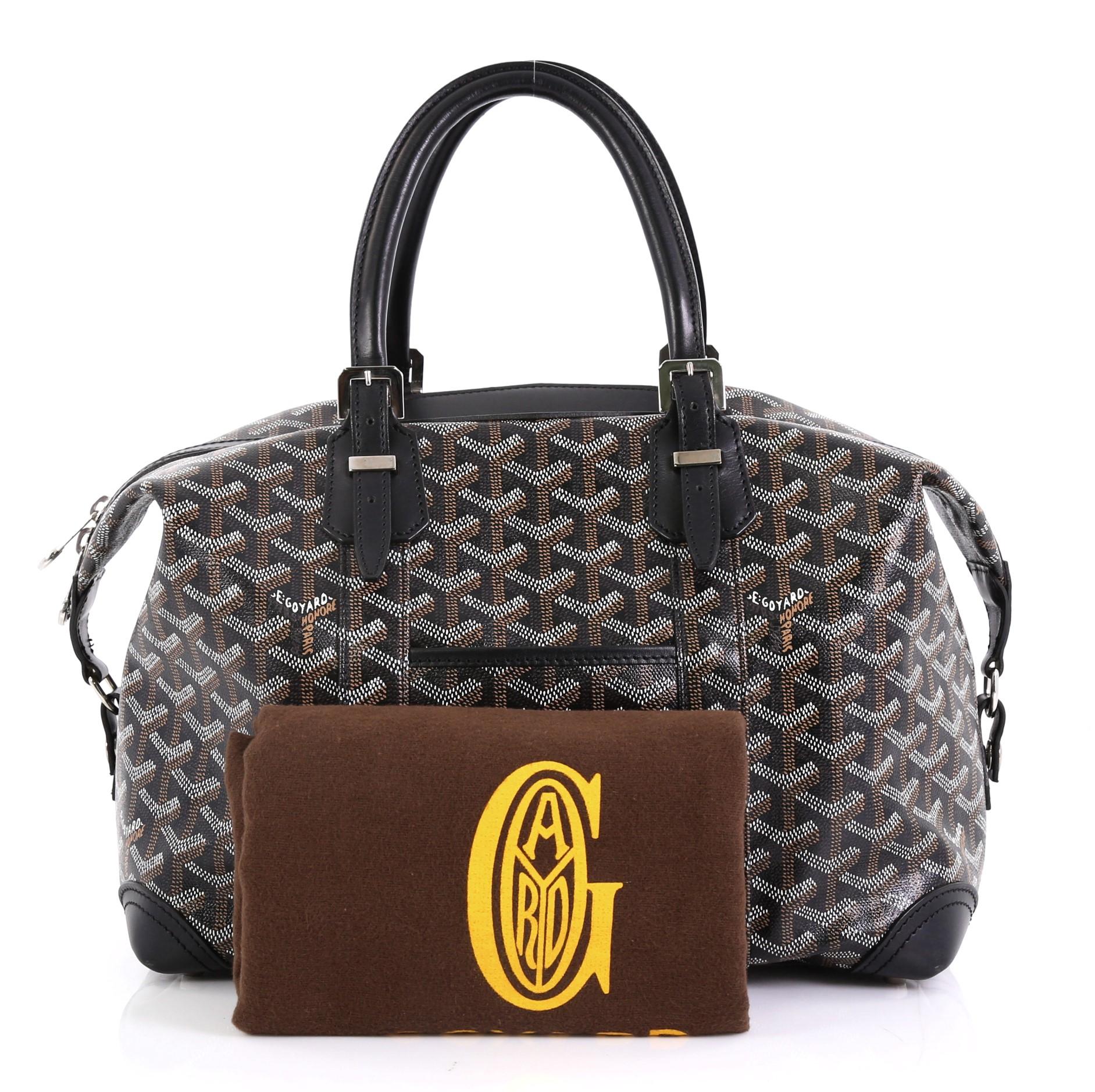 This Goyard Boeing Travel Bag Coated Canvas 30, crafted from black and brown coated canvas, features dual leather top handles, front slip pocket, and silver-tone hardware. Its two-way top zip closure opens to a yellow fabric interior with zip