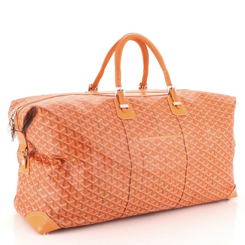 This Goyard Boeing Travel Bag Coated Canvas 65, crafted from orange coated canvas, features dual leather handles with belt details, exterior front pocket, leather trim and silver-tone hardware. Its zip closure opens to a yellow fabric interior with