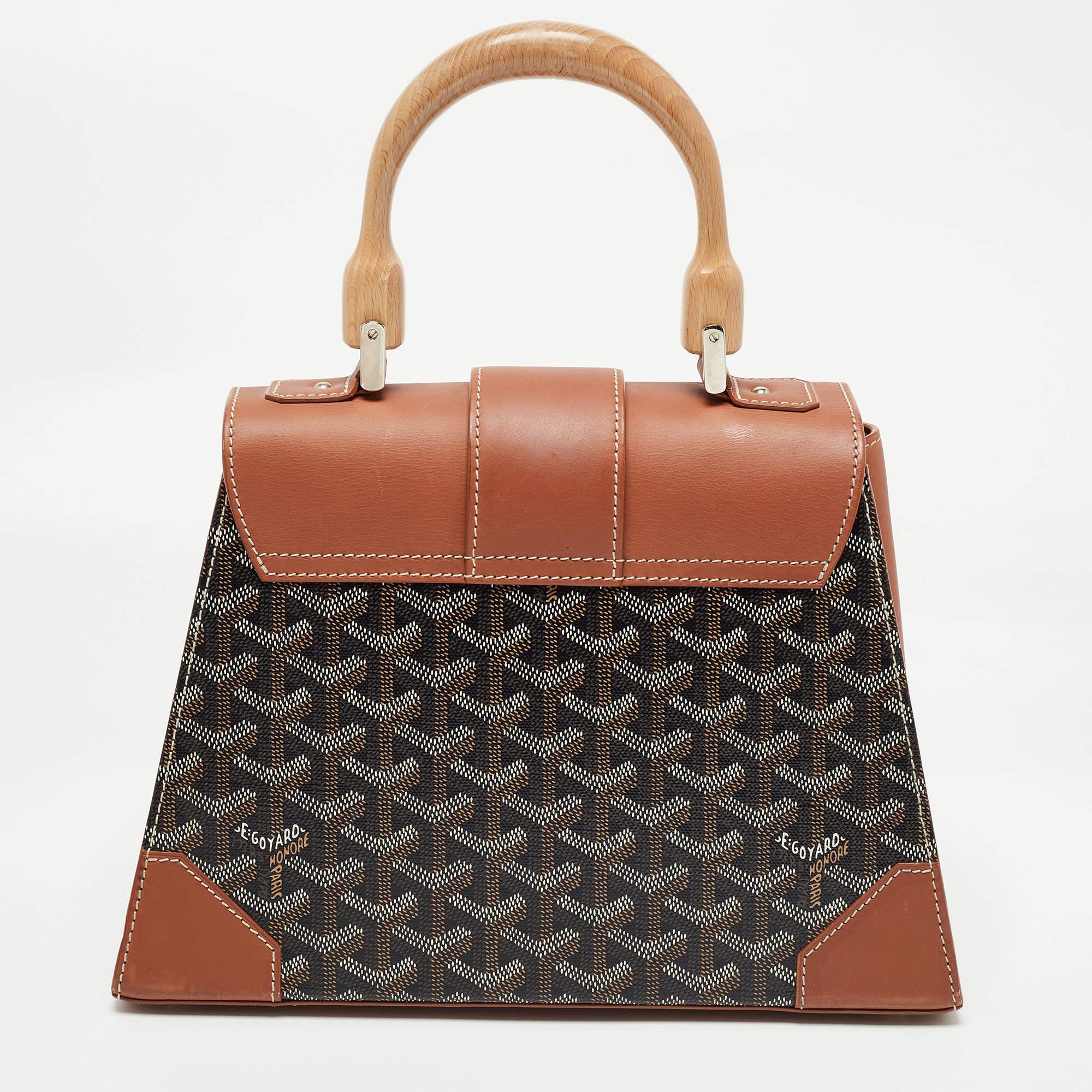 This handbag from Goyard will make the dream of countless women come true. Crafted from the brand's signature canvas and eather, this bag has a luscious brown shade, wood trims and a fold-in lock on the flap. While the shape and detailing elevate