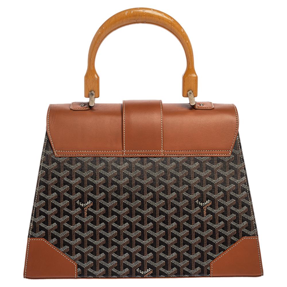 This handbag from Goyard will make the dream of countless women come true. Crafted from the brand's signature coated canvas and leather, this bag has a luscious brown shade, wood trims and a fold-in lock on the flap. While the shape and detailing