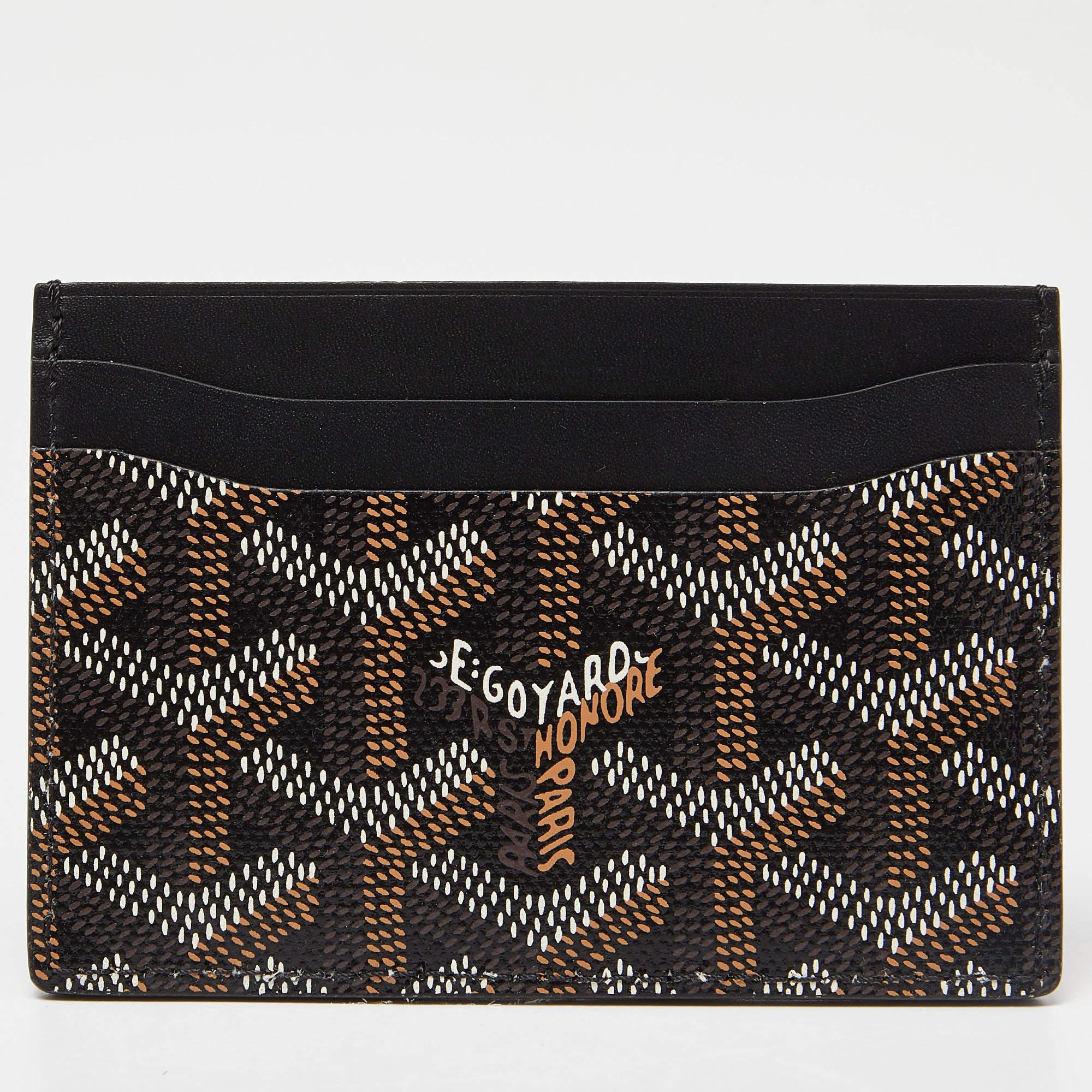Functional and stylish, this Saint Sulpice cardholder from Goyard is your next best buy. Crafted from the signature Goyardine coated canvas, this brown card holder features four card slots and leather lining on the insides. It is sleek and can be