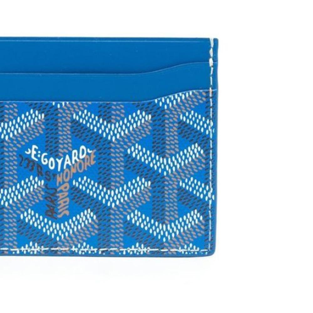 Featuring a cartoon Scrooge McDuck Print, this Blue Goyard St Sulpice Wallet has been handpainted as part of Rewind Vintage's emotional baggage collection. Crafted from Goyardine Canvas with 4 card slots, a front embossed logo stamp, and a