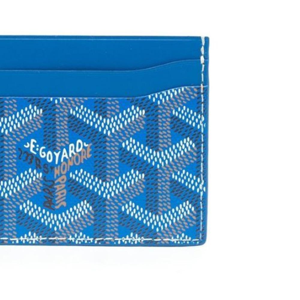 Dieses blaue Goyard St. Sulpice Portemonnaie mit Dagobert Duck-Cartoon-Aufdruck wurde als Teil der emotionalen Baggage-Kollektion von Rewind Vintage handbemalt. Gefertigt aus Goyardine Canvas mit 4 Kartenfächern, einer Logoprägung auf der