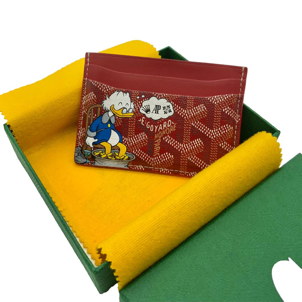 Crafted from Goyardine Canvas, a coloured textile made from cotton, linen and hemp, this red monogram Slot card Wallet from Goyard is adorned with an all-over cartoon print, especially hand-painted as a part of Rewind Vintage's Emotional Baggage