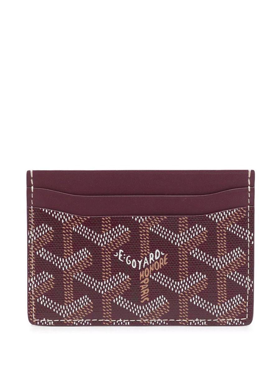 Crafted from Goyardine Canvas, a coloured textile made from cotton, linen and hemp, this burgundy monogram Slot card Wallet from Goyard is adorned with an all-over cartoon print, especially hand-painted as a part of Rewind Vintage's Emotional