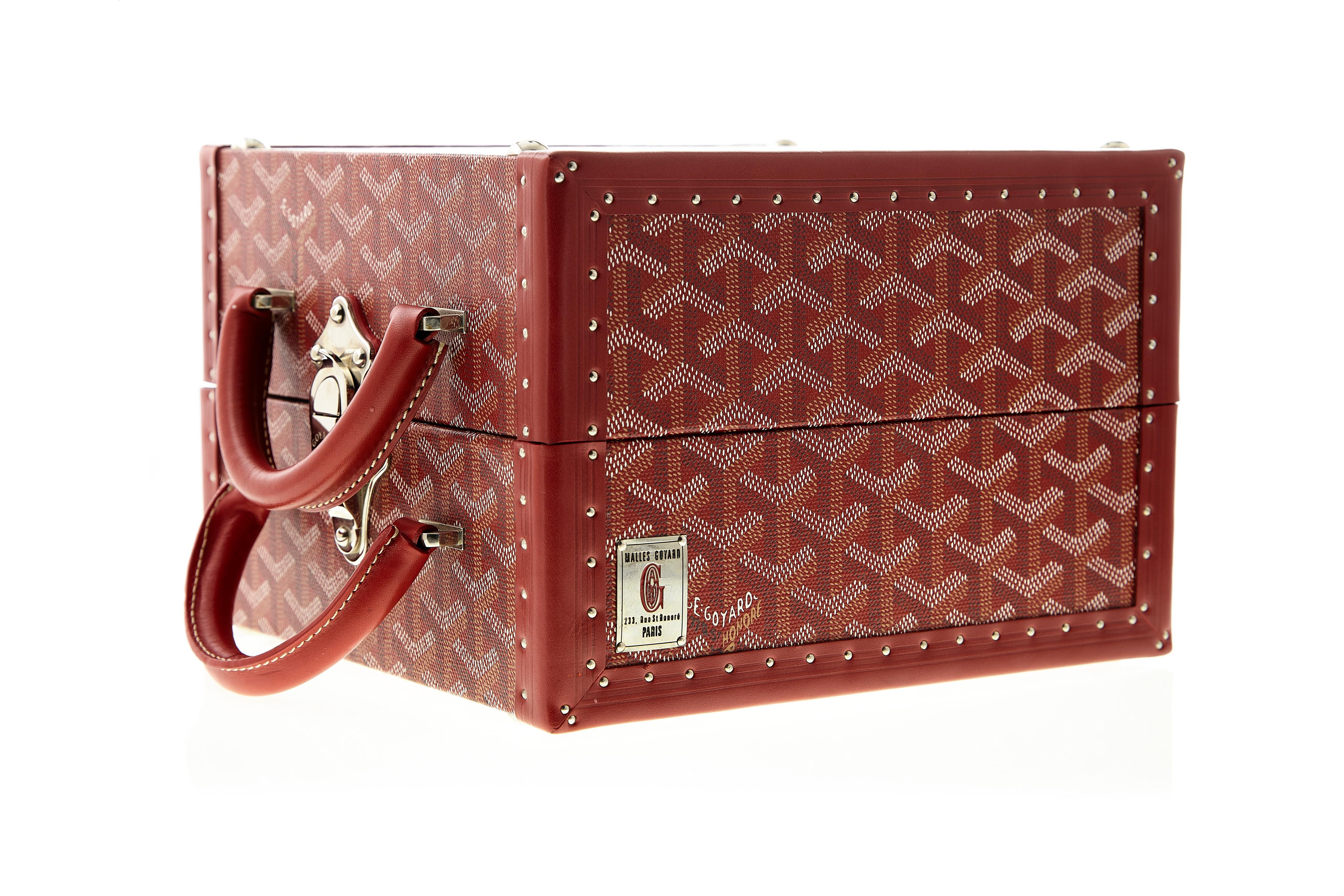 A rare and coveted Goyard dog bowl, featuring one side for water and the other for food. Done in a striking red chevron.