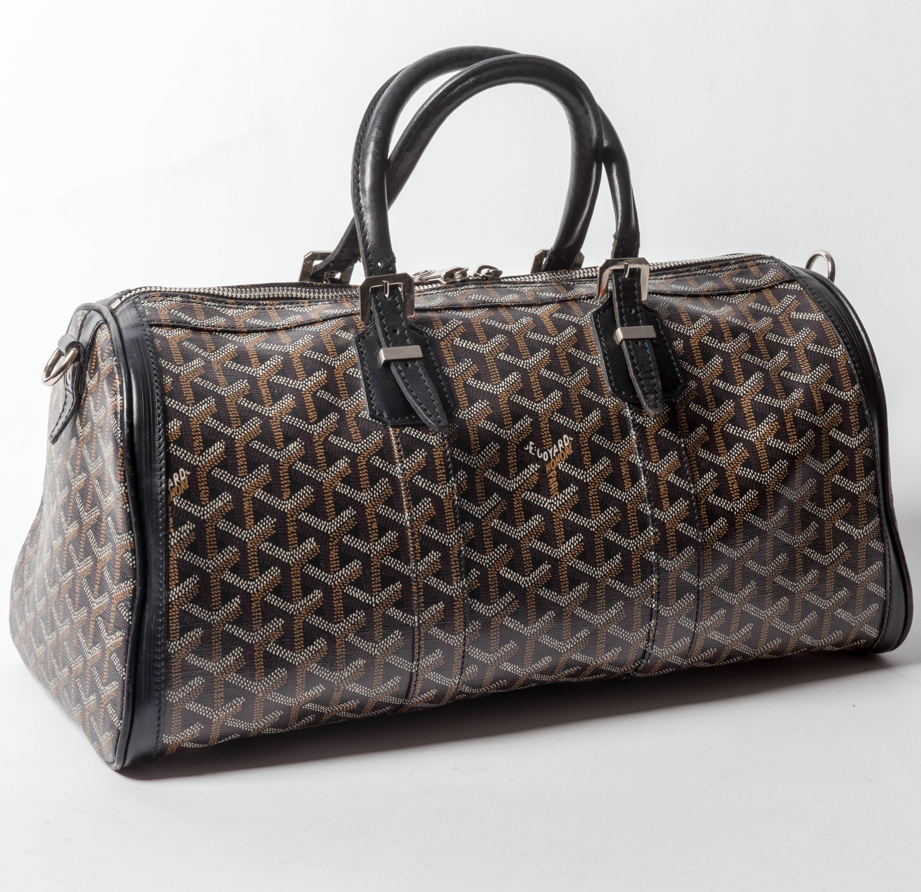 Black and multicolor stenciled Goyardine coated canvas Goyard Croisiere 40 with palladium hardware, protective feet at base, black cowhide leather trim, dual rolled top handles, marigold woven lining, single zip pocket at interior wall and two-way