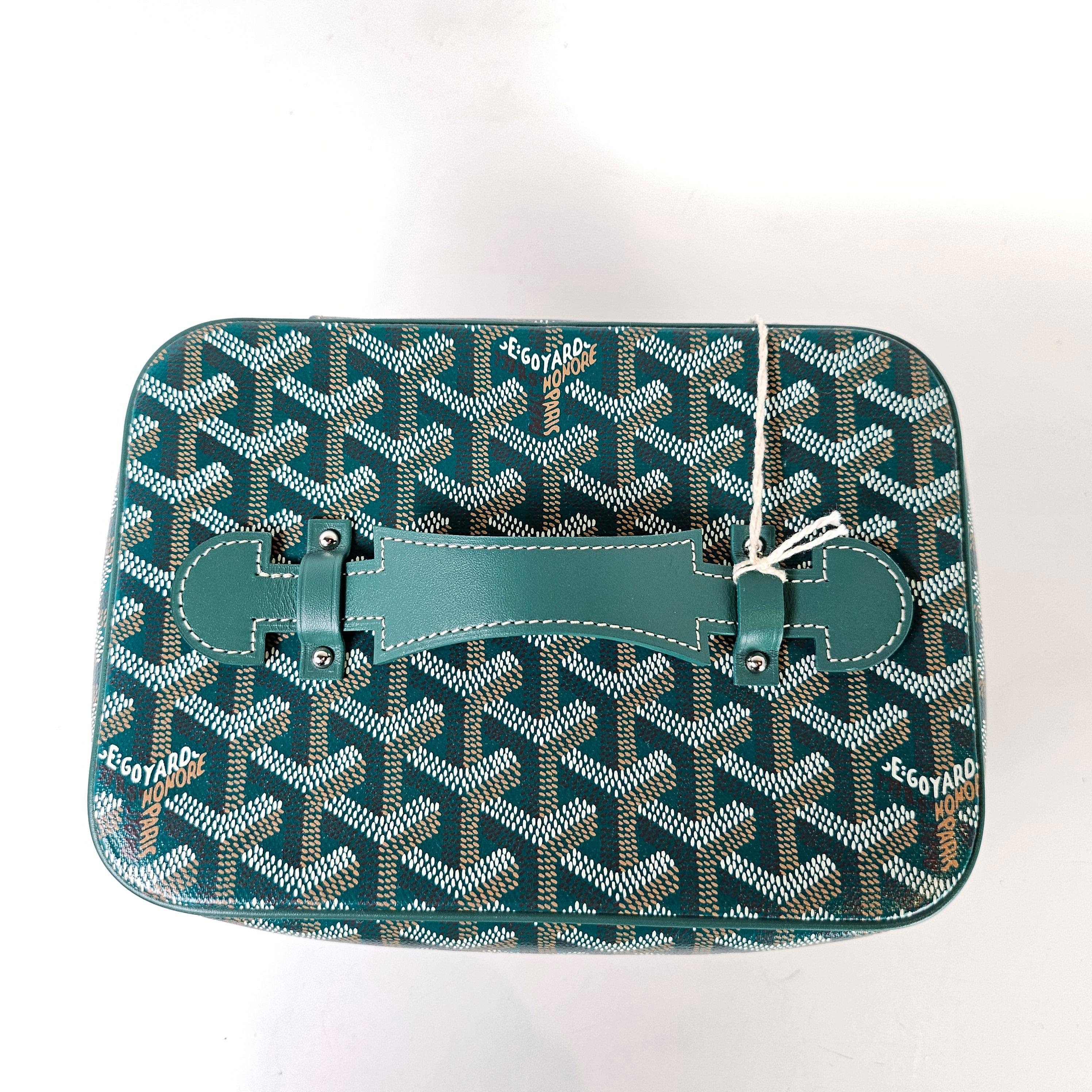 Condition: This authentic Goyard bag is in pristine pre-loved condition. There is some faint denting on the top leather.

Includes: Dust bag, mirror, tag

Features: Zip closure, mirror, interior pockets, leather top handle

Material: Coated canvas