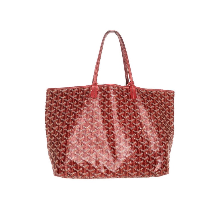 This stylish tote is crafted of signature Goyard chevron printed coated canvas in rouge. The shoulder bag features sturdy rouge leather strap top handles and leather top crest trim. The top is open to a spacious ivory canvas interior with a matching