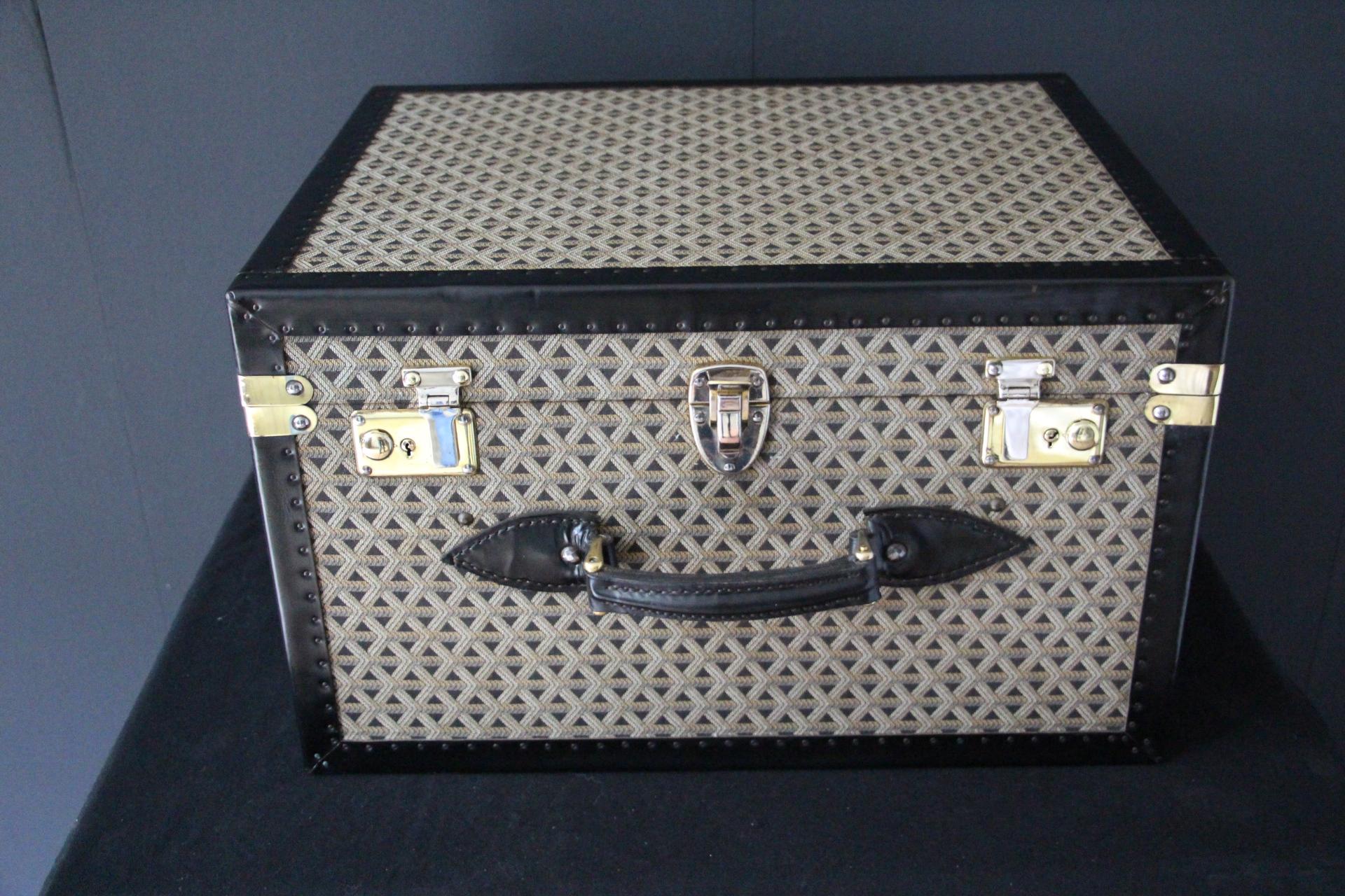This wonderful Goyard hat trunk features the very sought after chevrons woven canvas as well as steel lock and clasps . It has got also a beautiful black trim all around. Its 2 large black leather handles, located on its front and on its side are