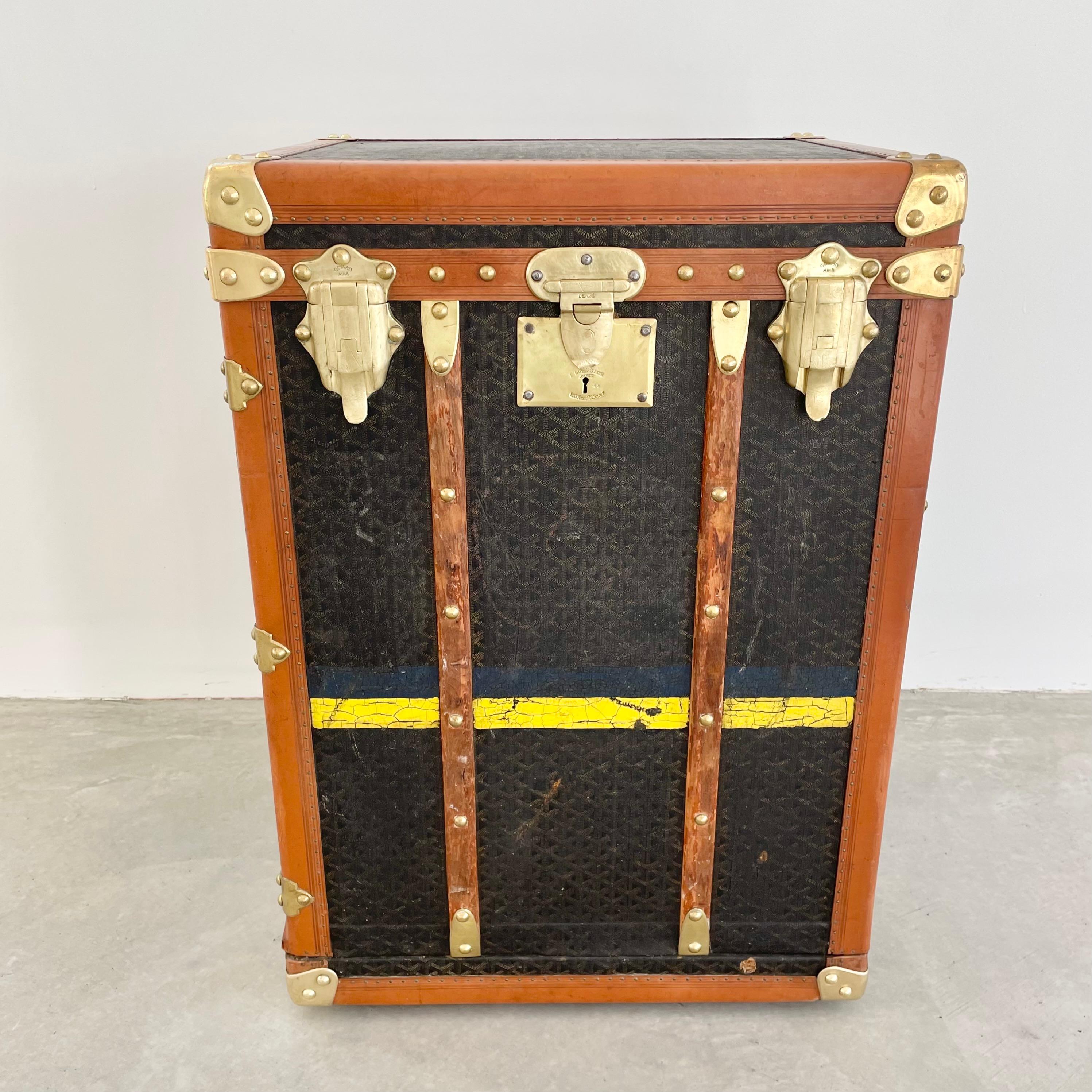 Classic vintage Goyard trunk. Made in the 1920s. Large wooden frame wrapped in the iconic Goyard canvas print with saddle leather and brass hardware as well as wooden supports on the front and back. Goyard branding engraved on the brass hardware