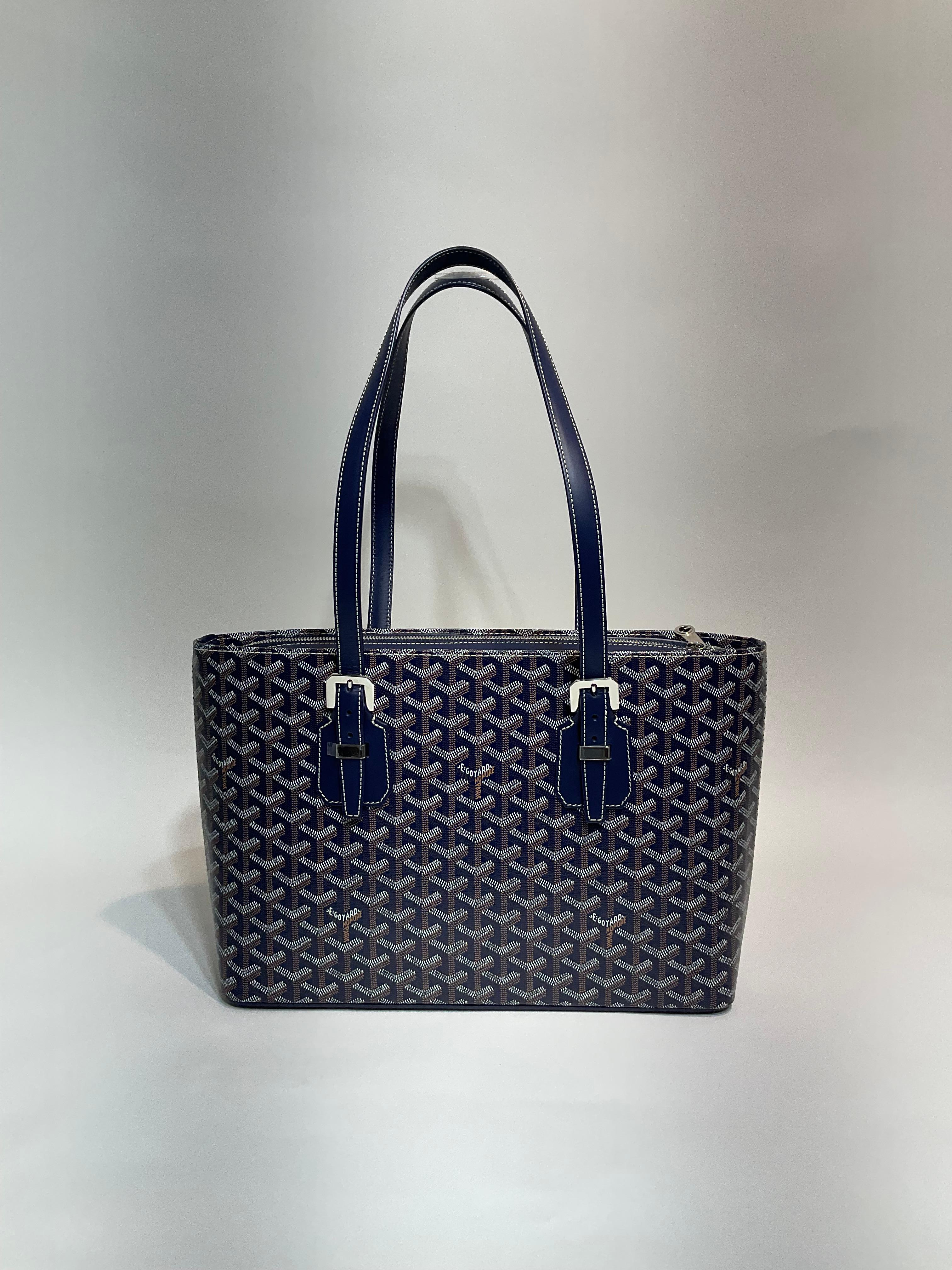 Goyard Navy Goyardine Canvas PM Tote
Perhaps carried one time; appears never carried. 
Rich navy blue Goyardine canvas with signature chevron patterned monogram.  Smooth leather trimmings and straps.  Adjustable polished silver buckles and zippered