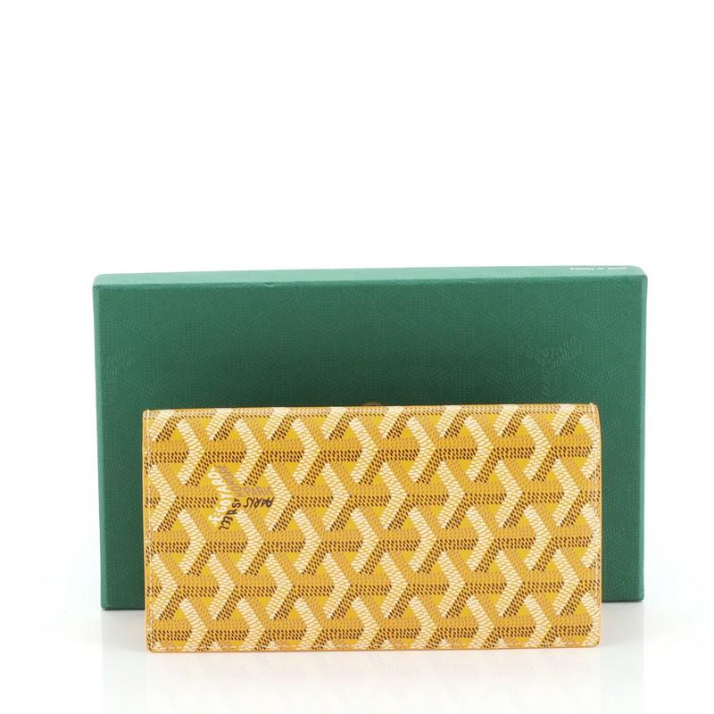 This Goyard Phone Wallet Coated Canvas, crafted from yellow coated canvas. It opens to a yellow leather interior with slip pockets and multiple card slots. 

Condition: Excellent. Slight creasing on sides, minimal wear in interior.
Accessories:
