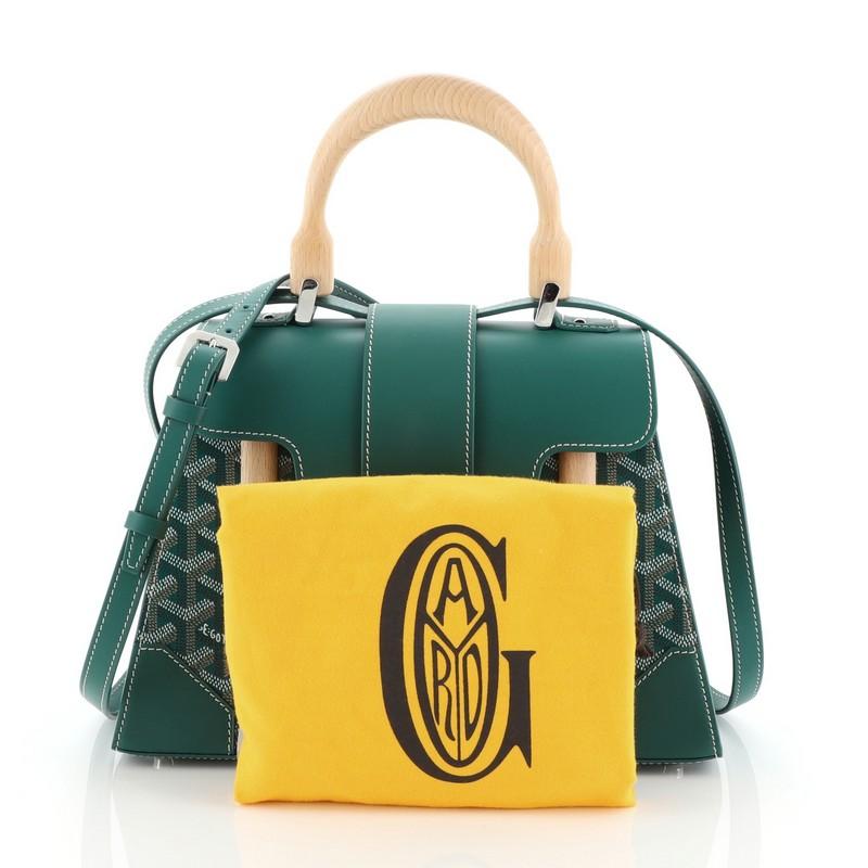 This Goyard Saigon Top Handle Bag Leather PM, crafted from green leather, features wooden top handle and silver-tone hardware. Its flap opens to a yellow fabric interior with slip pocket. 

Estimated Retail Price: $3,280
Condition: Excellent. Slight