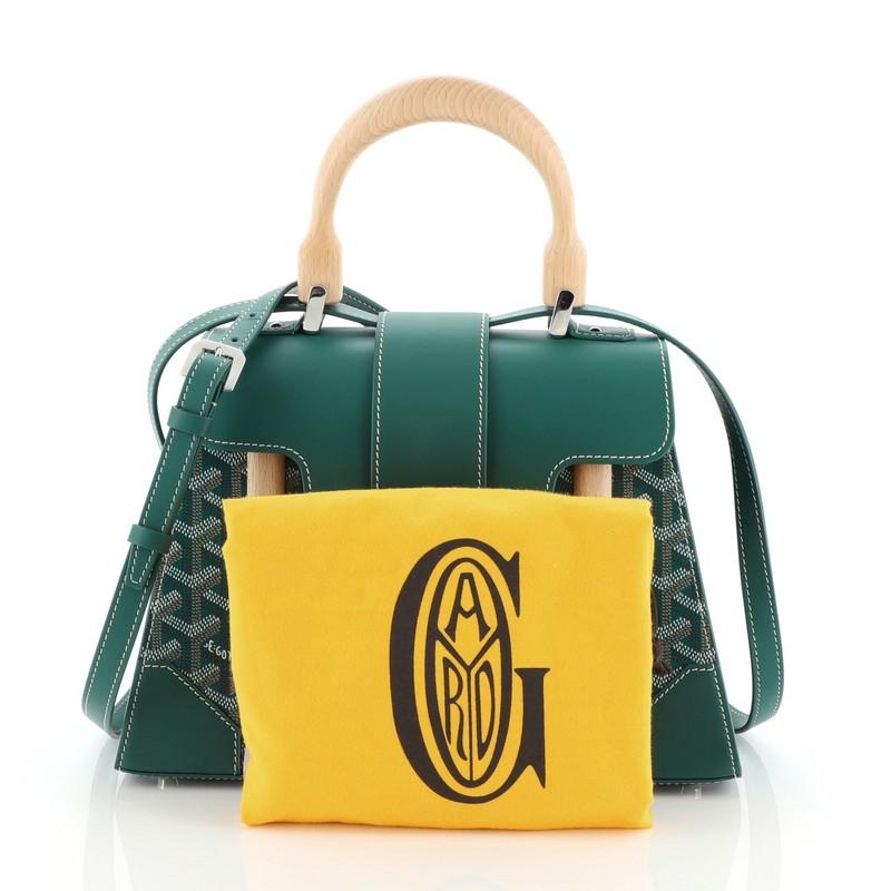 Ce Goyard Saigon Top Handle Bag Leather PM:: confectionné en cuir vert:: présente une poignée supérieure en bois et une quincaillerie de couleur argentée. Son rabat s'ouvre sur un intérieur en tissu jaune avec une pochette. 

Prix de détail estimé :