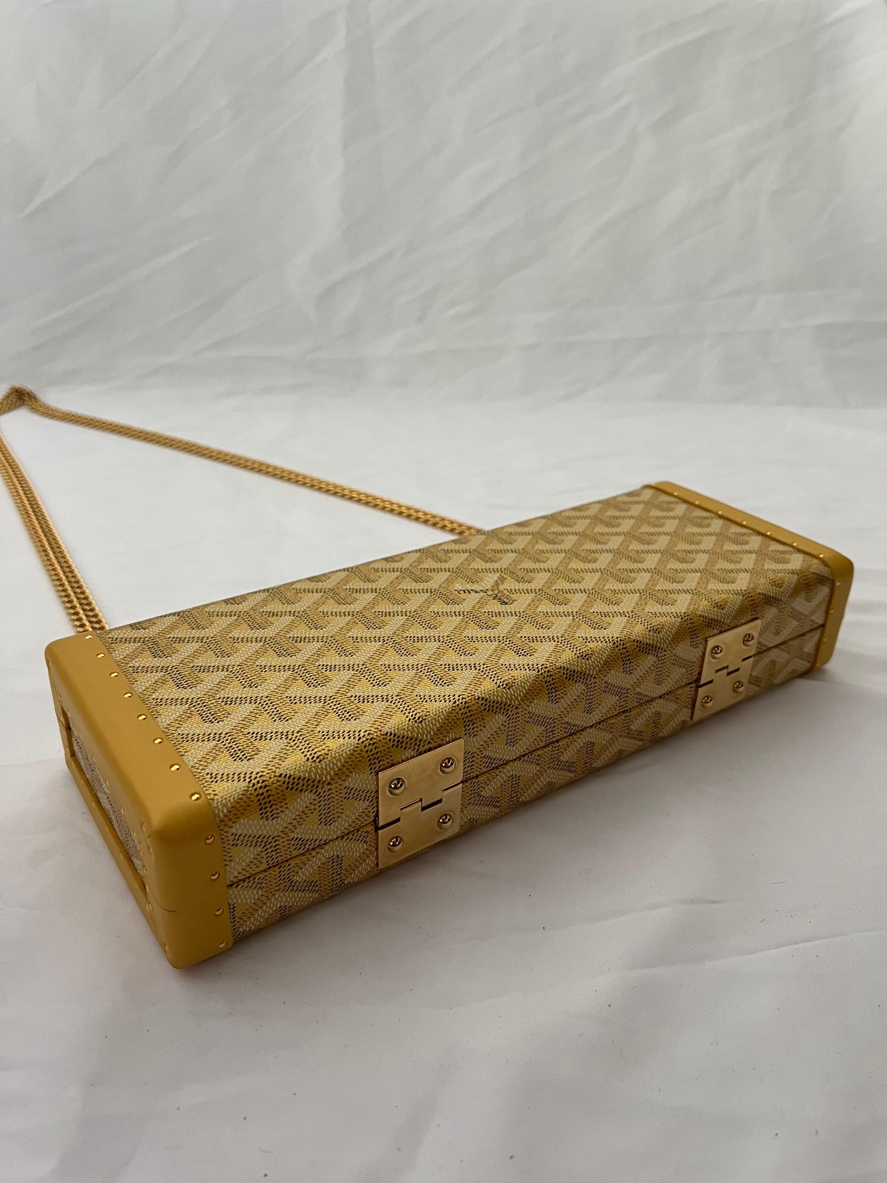 - Yellow/ Gold
- Signature Goyard print
- Gold tone hardware
- Removable chain link shoulder strap, drops 21.5”
- Double clasp closure on the top
- Single interior pocket
- Protective feet at the base
- Includes dust bag 
