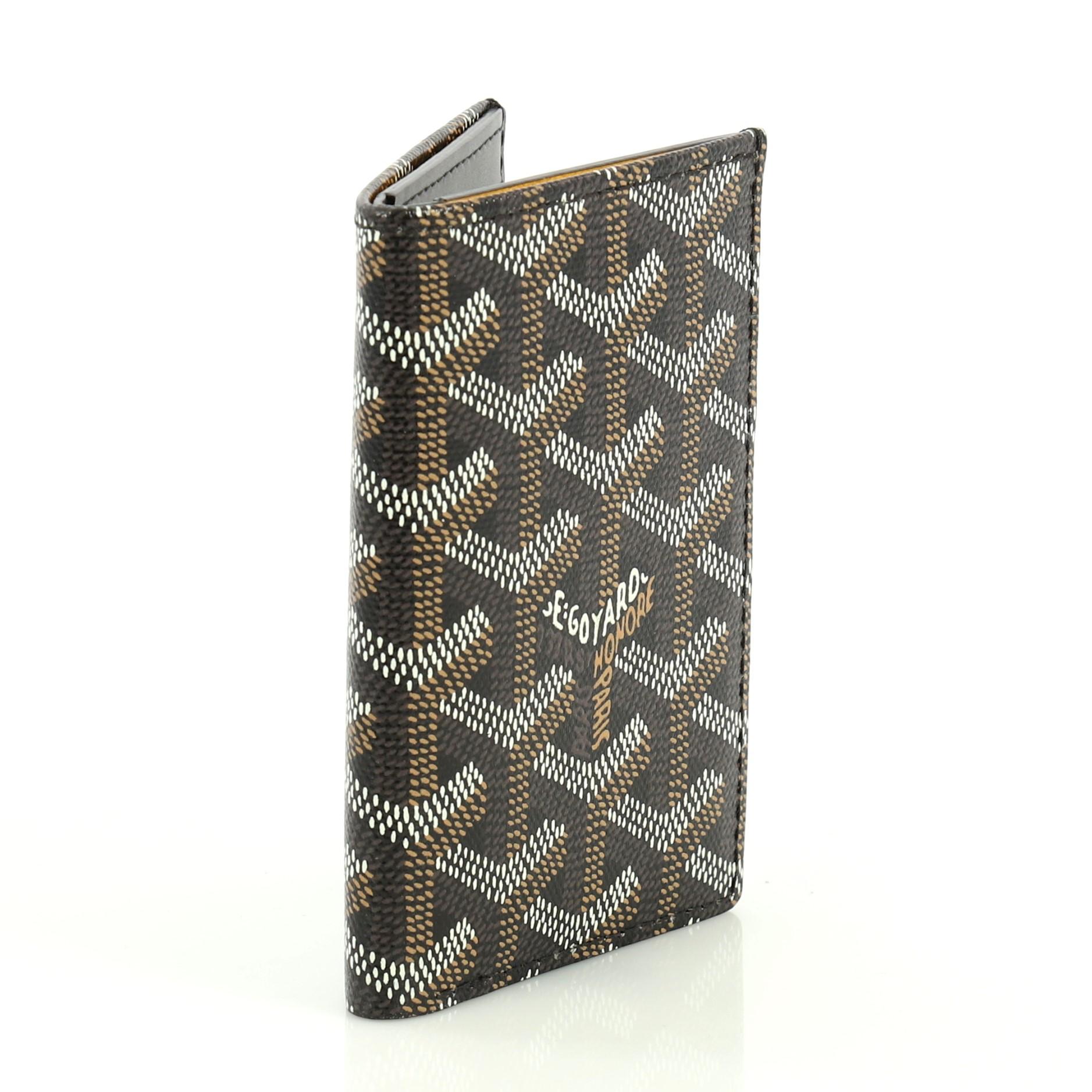 This Goyard Saint Pierre Card Holder Coated Canvas, crafted from brown Goyardine coated canvas. It opens to a black leather interior with multiple card slots, slip pockets and bill compartment. 

Condition: Excellent. Creasing on exterior, light