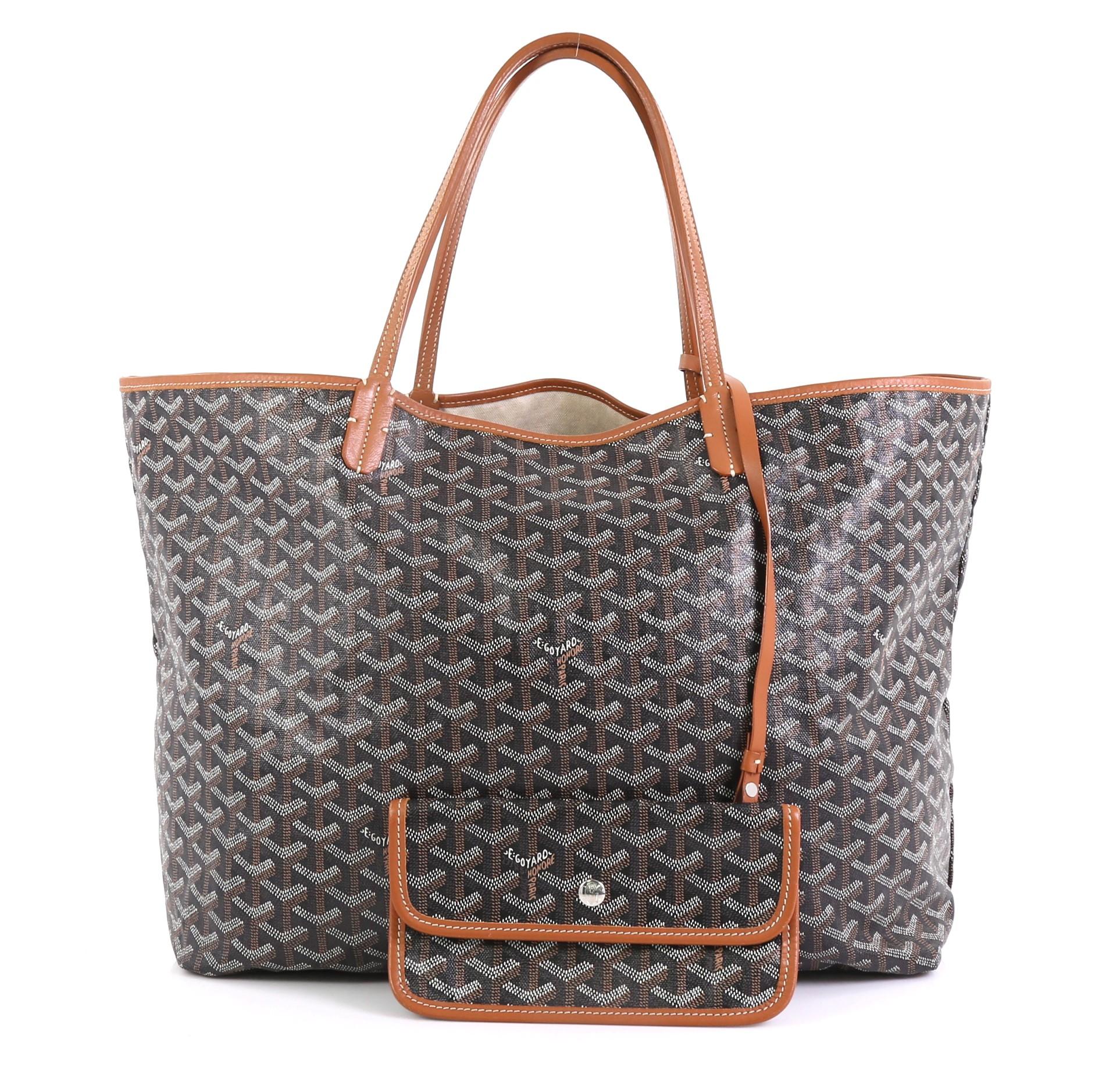 This Goyard St. Louis Tote Coated Canvas GM, crafted in black coated canvas, features flat leather handles and silver-tone hardware. Its wide open top showcases a neutral fabric interior. 

Condition: Good. Small tear on base corner. Minor wear on
