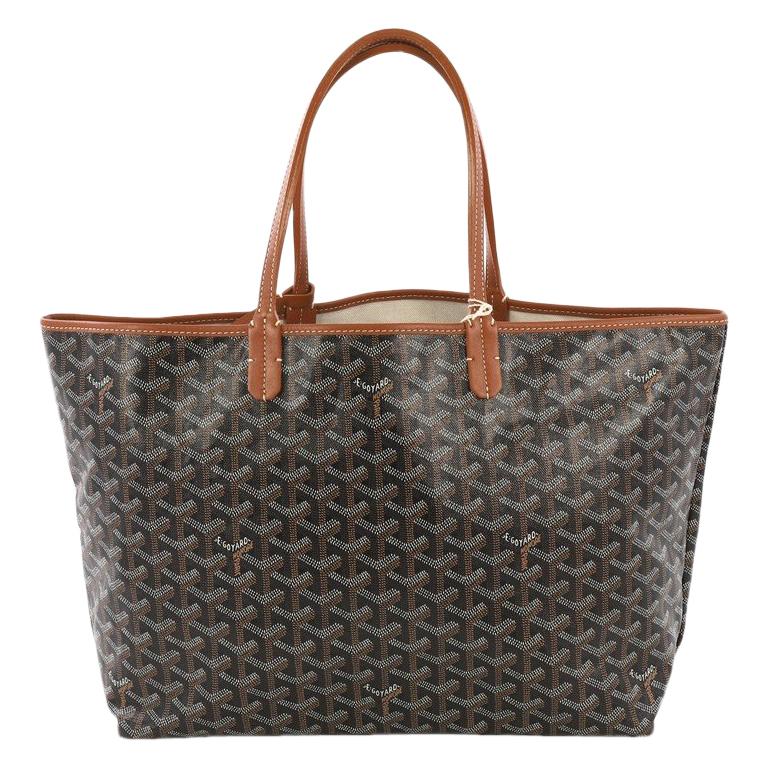 This Goyard St. Louis Tote Coated Canvas PM, crafted in black coated canvas, features flat leather handles, leather trim, and silver-tone hardware. Its wide open top showcases a beige fabric interior. 

Condition: Excellent. Light cracking on handle