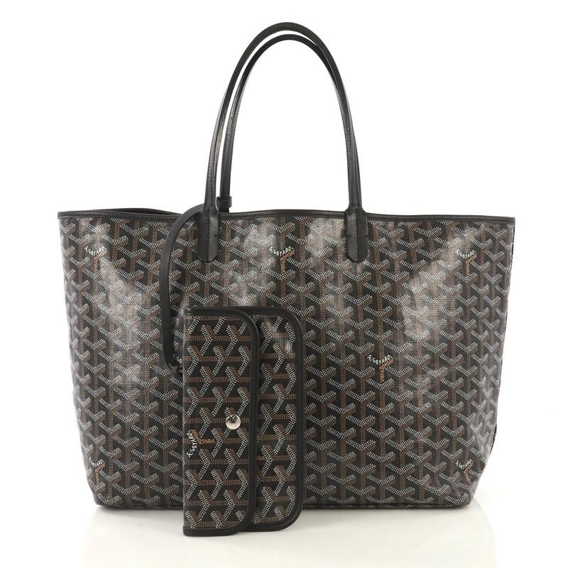 This Goyard St. Louis Tote Coated Canvas PM, crafted in black coated canvas, features flat leather handles, leather trim, and silver-tone hardware. Its wide open top showcases a beige fabric interior. 

Condition: Very good. Wear on handles,