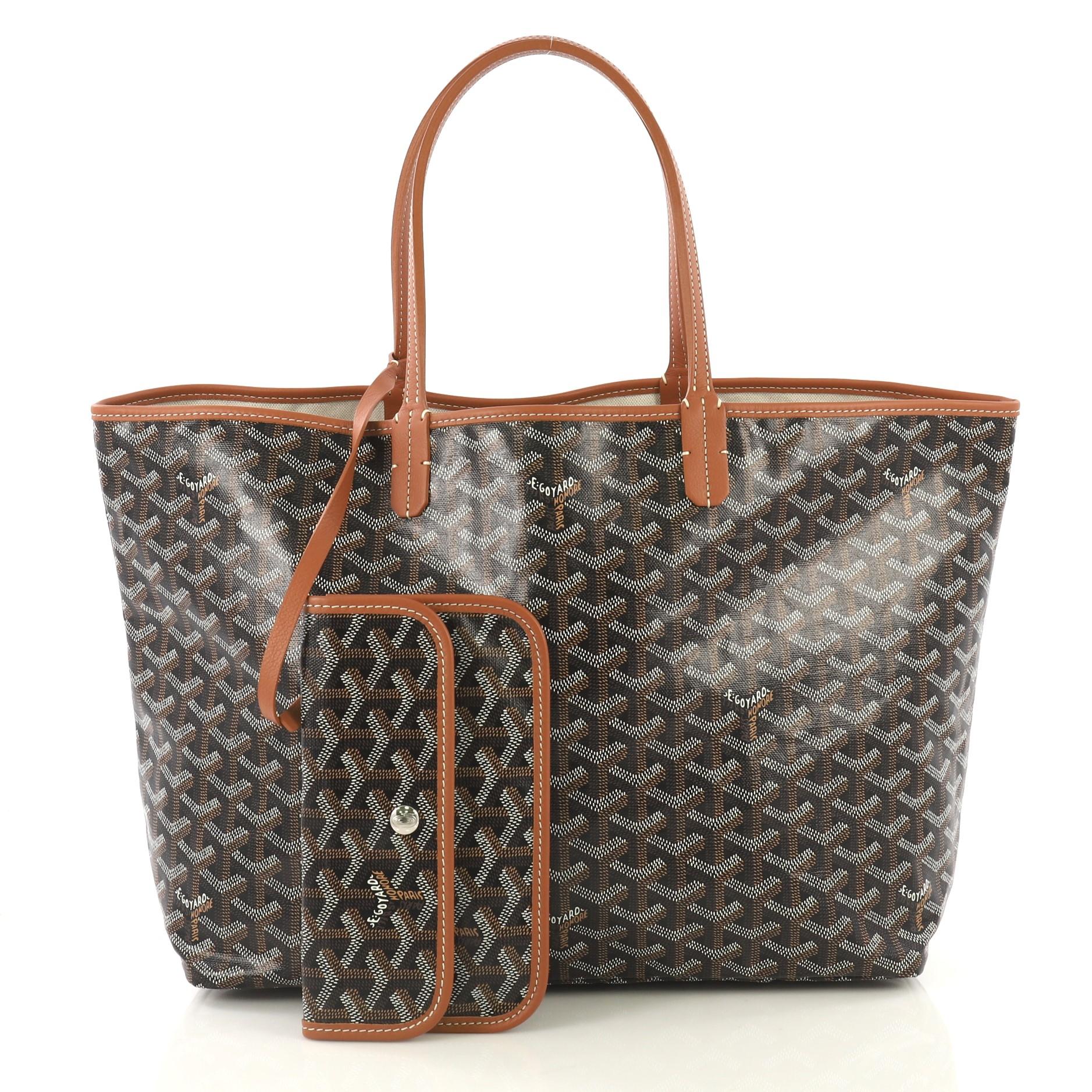 This Goyard St. Louis Tote Coated Canvas PM, crafted in black and brown coated canvas, features flat leather handles, leather trim, and silver-tone hardware. Its wide open top showcases a beige canvas interior. 

Condition: Excellent. Scratches on