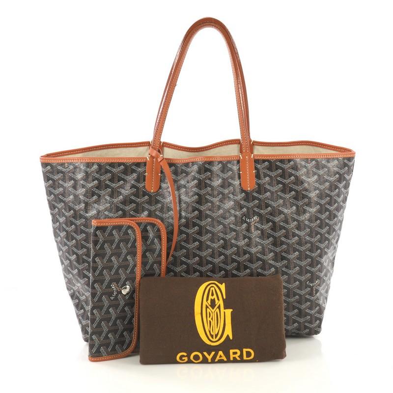 This Goyard St. Louis Tote Coated Canvas PM, crafted from black coated canvas, features dual slim leather handles, leather trim, and silver-tone hardware. Its wide open top showcases a beige fabric interior. 

Condition: Good. Cracking on handle wax