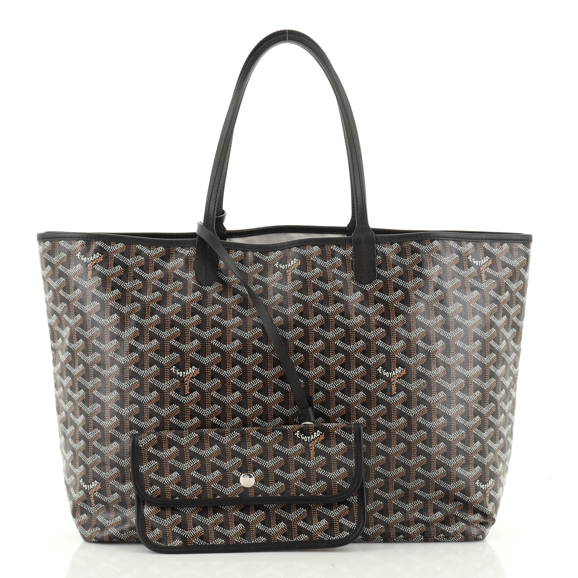 This Goyard St. Louis Tote Coated Canvas PM, crafted from black and brown coated canvas, features dual slim leather handles, leather trim, and gunmetal-tone hardware. Its wide open top showcases a neutral fabric and canvas interior. 

Condition: