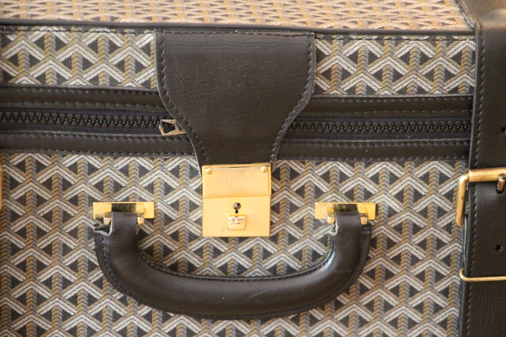 This beautiful Goyard suitcase features the very sought after woven canvas and black leather.Its sturdy and comfortable handle is in black leather .Its lock is in brushed brass.
All around, it opens thanks to its zip.Please note that its zip is a