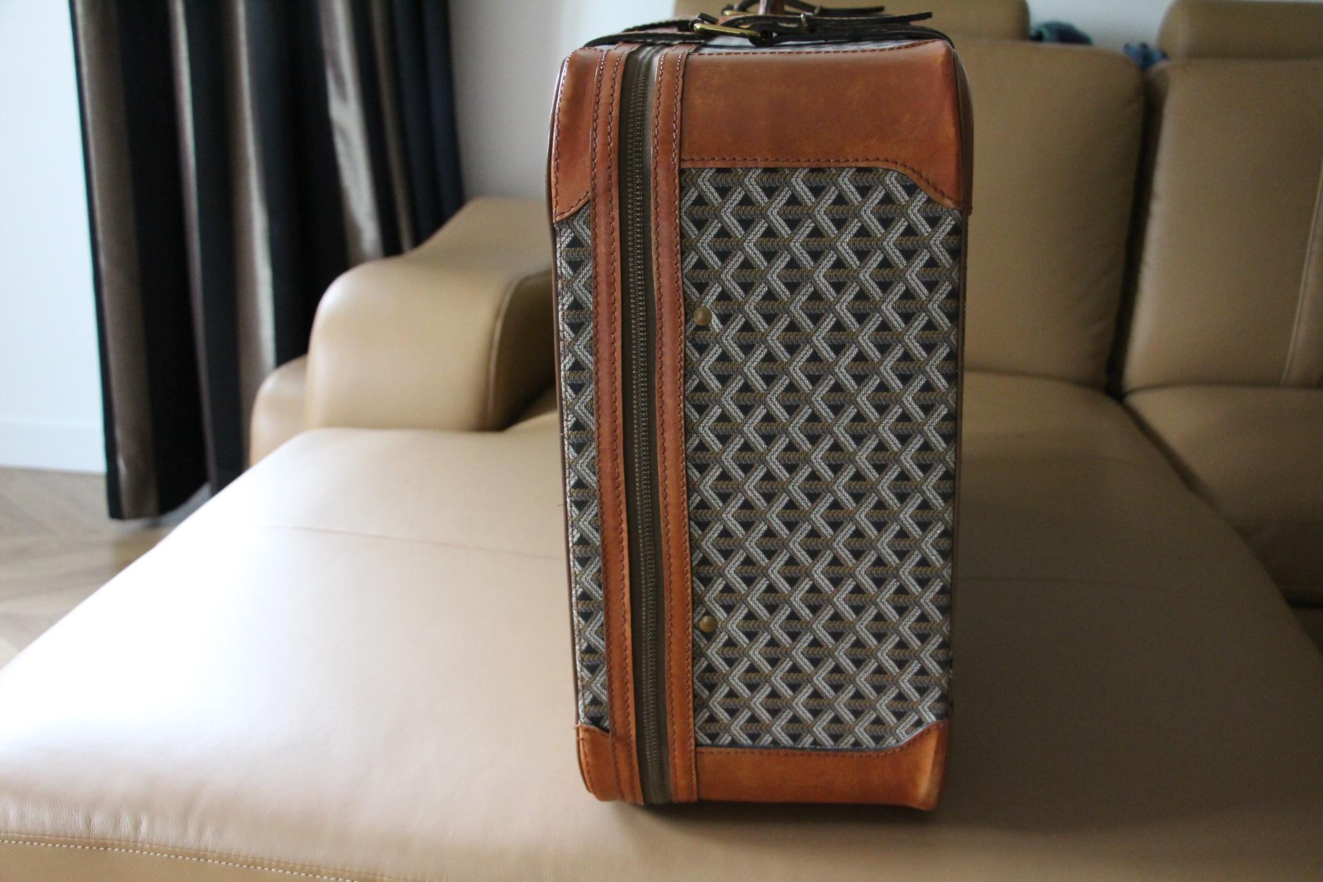 This beautiful Goyard suitcase features the very sought after woven canvas and honey color leather.Its sturdy and comfortable handle is in black leather .Its lock is in brushed brass.
All around, it opens thanks to its zip.Please note that its zip