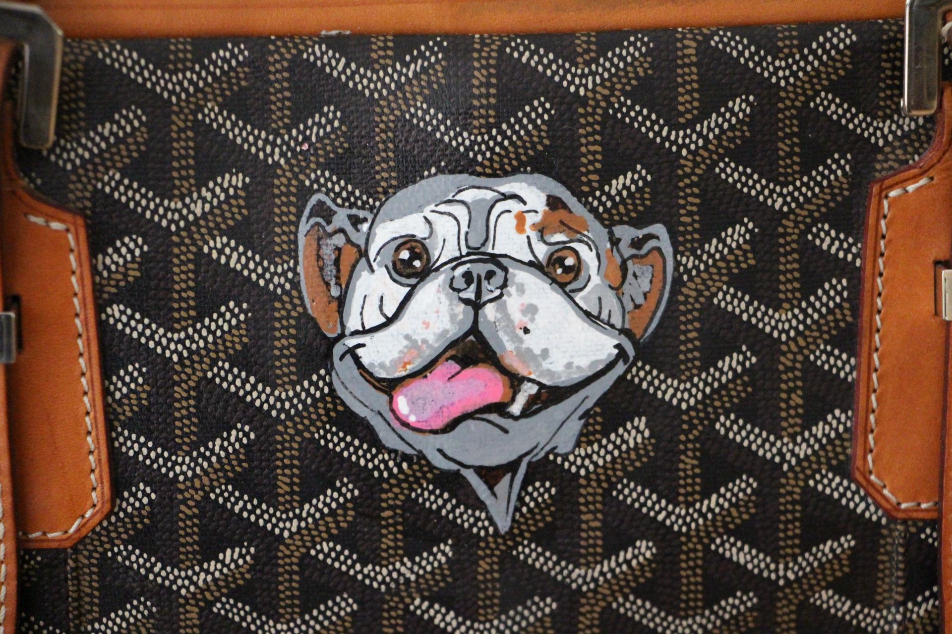 This beautiful Goyard suitcase features the very sought after chevrons canvas and honey color leather.Its sturdy and comfortable adjustable handles are in light brown leather as well as all its trims.It has got a flat pocket on the front..Its