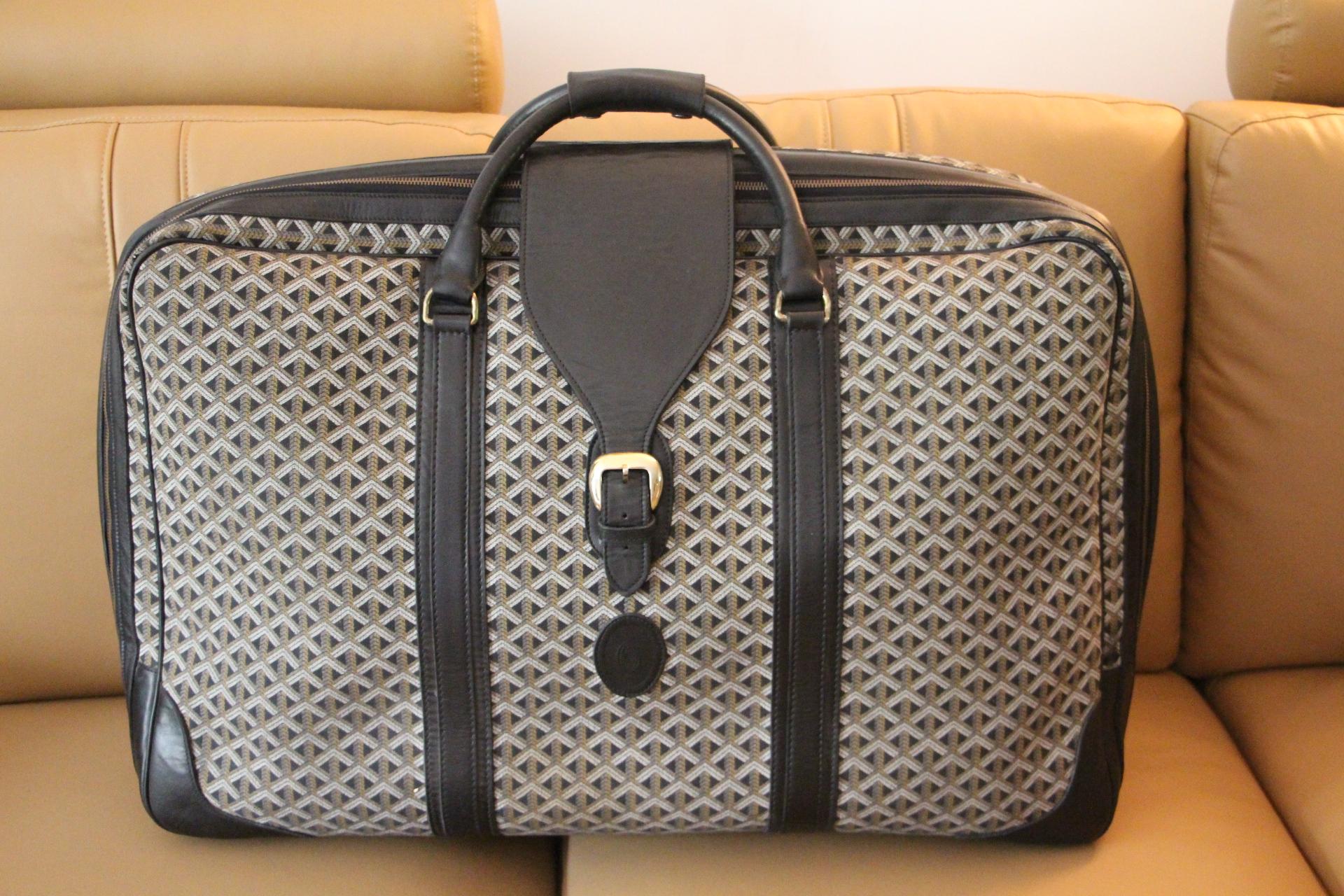 This beautiful Goyard suitcase features the very sought after woven canvas and black leather.Its sturdy and comfortable handles are in black eather as well as its large flap.It also features an oval leather escutcheon embossed with Goyard logo.
All