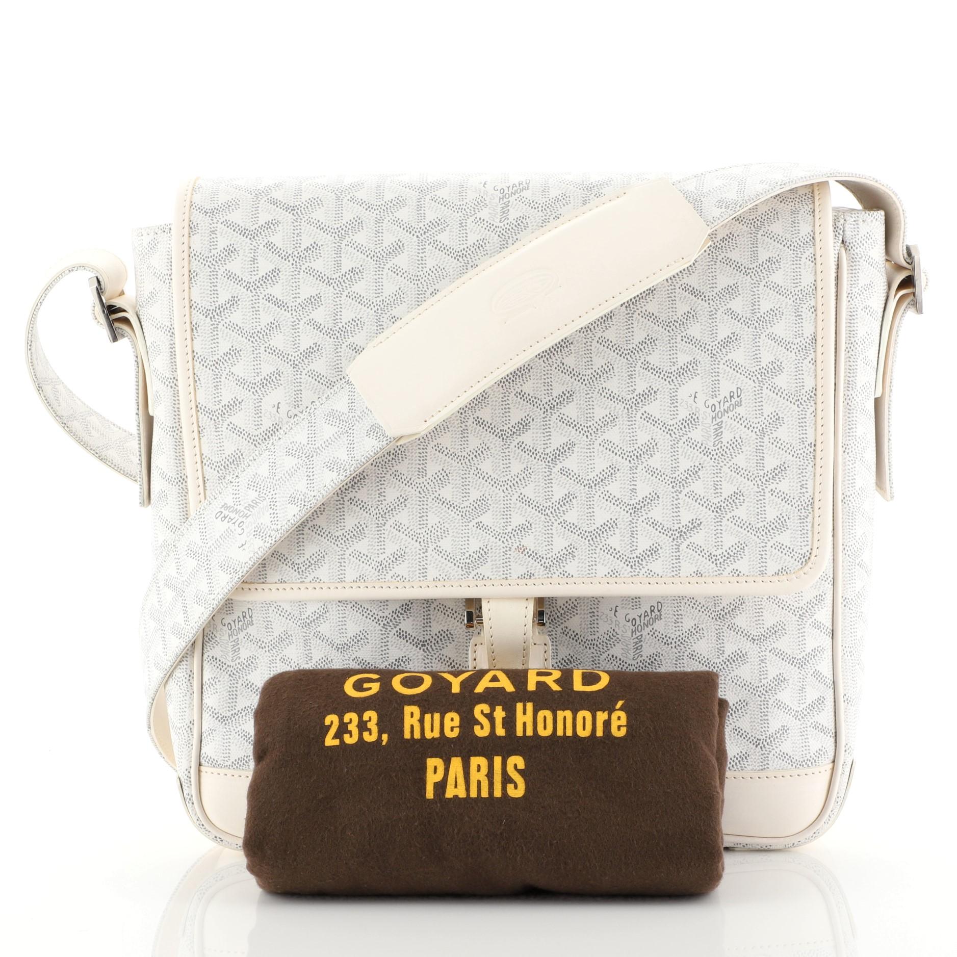 This Goyard Urbain Messenger Bag Coated Canvas, crafted in white coated canvas, features an adjustable shoulder strap, leather trim and silver-tone hardware. Its buckle closure opens to a yellow fabric interior with slip pockets. 

Estimated Retail