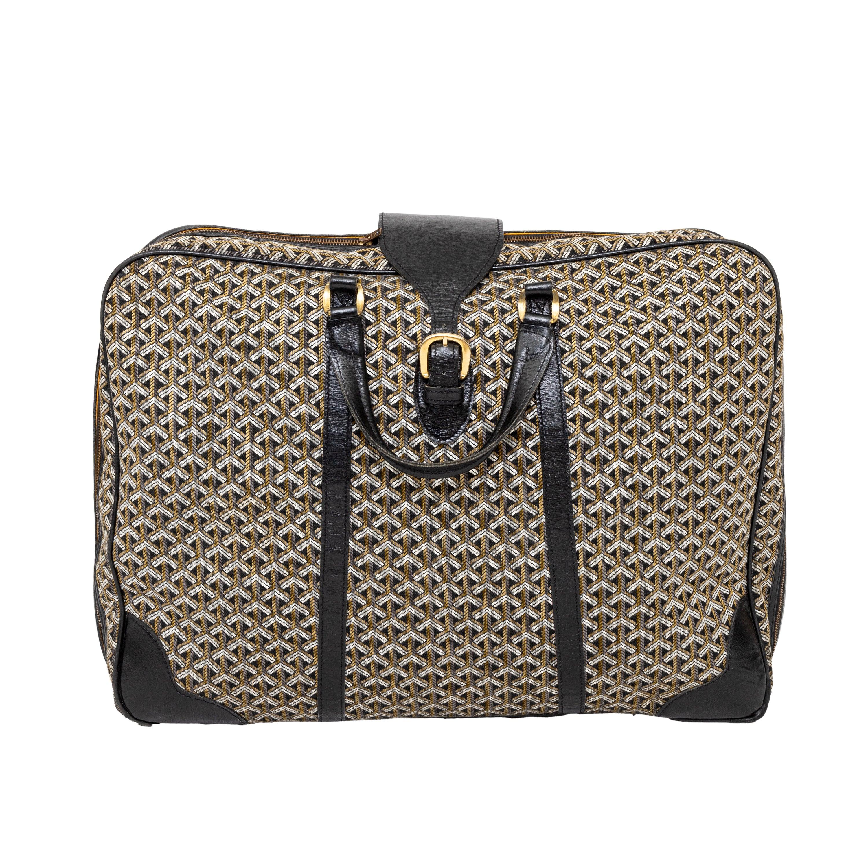 Elevate your travel game with the Goyard Vintage Travel Bag from the 70s. Crafted with the signature Goyard print in woven canvas and black leather trims, this rare and iconic bag provides both style and durability. Its sturdy leather handles,